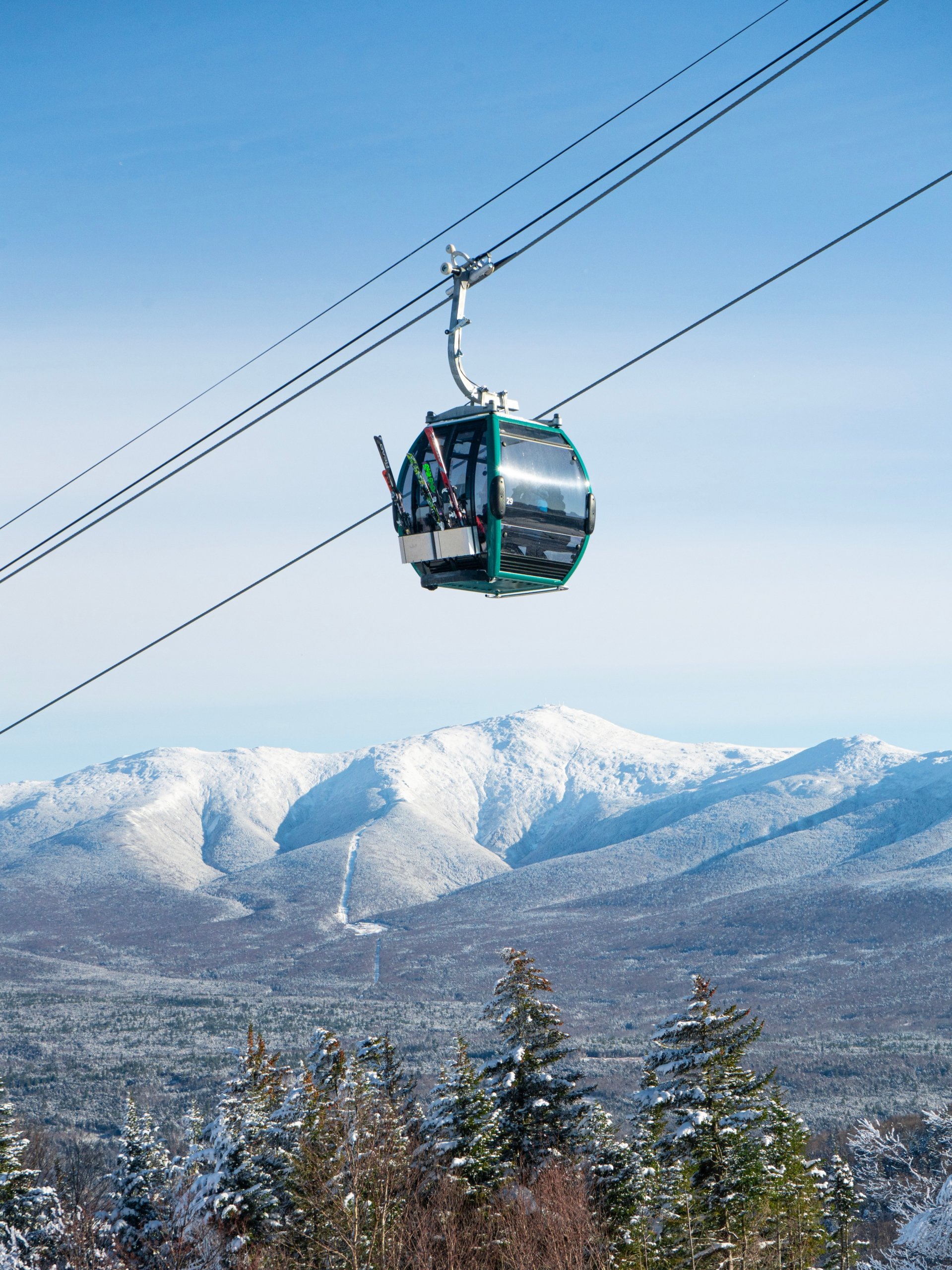 A ski gondola carries riders up a snowy mountain at Bretton Woods.
