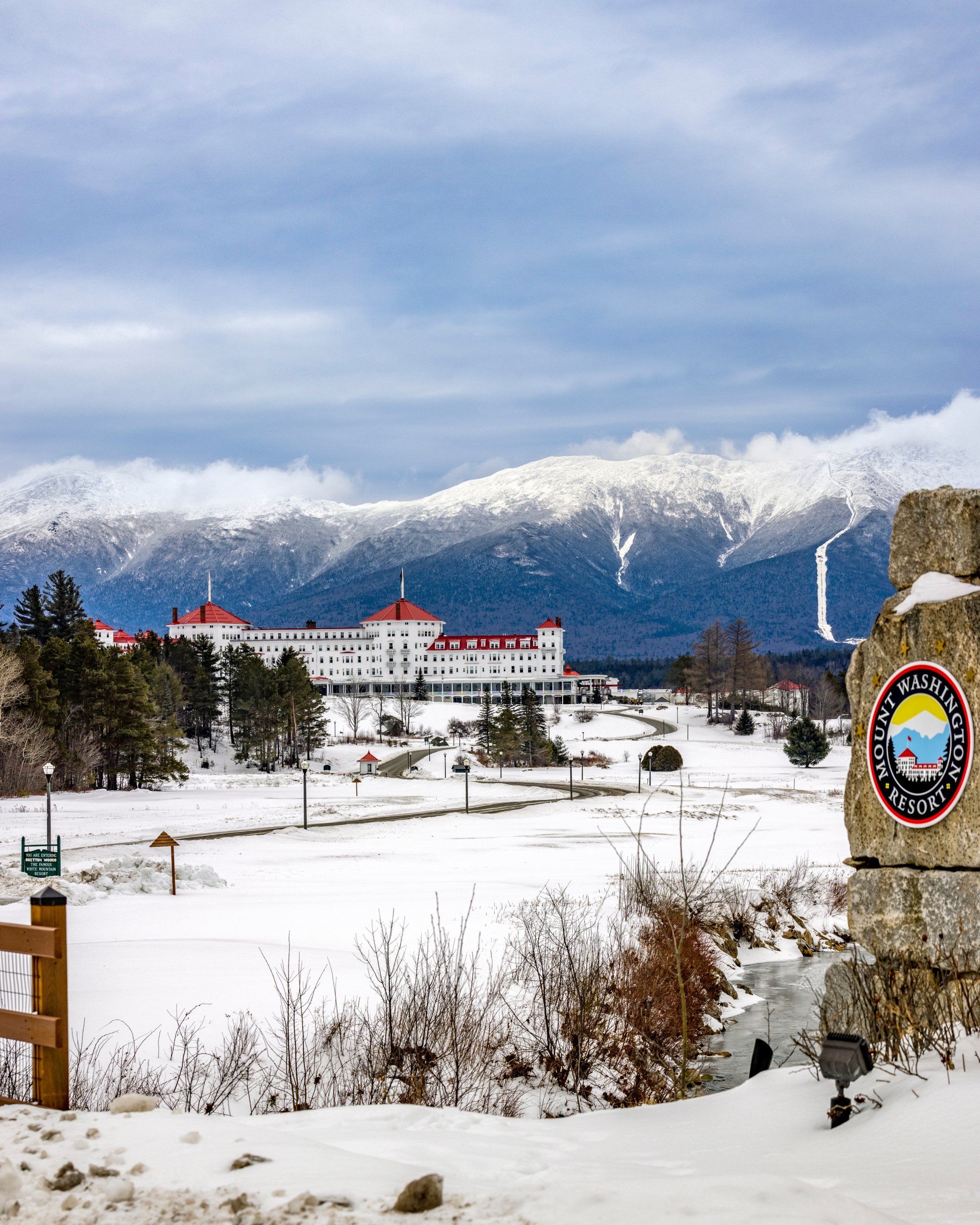 A winding road leads to Mount Washington Resort and Spa sitting at the base of snowy mountains.