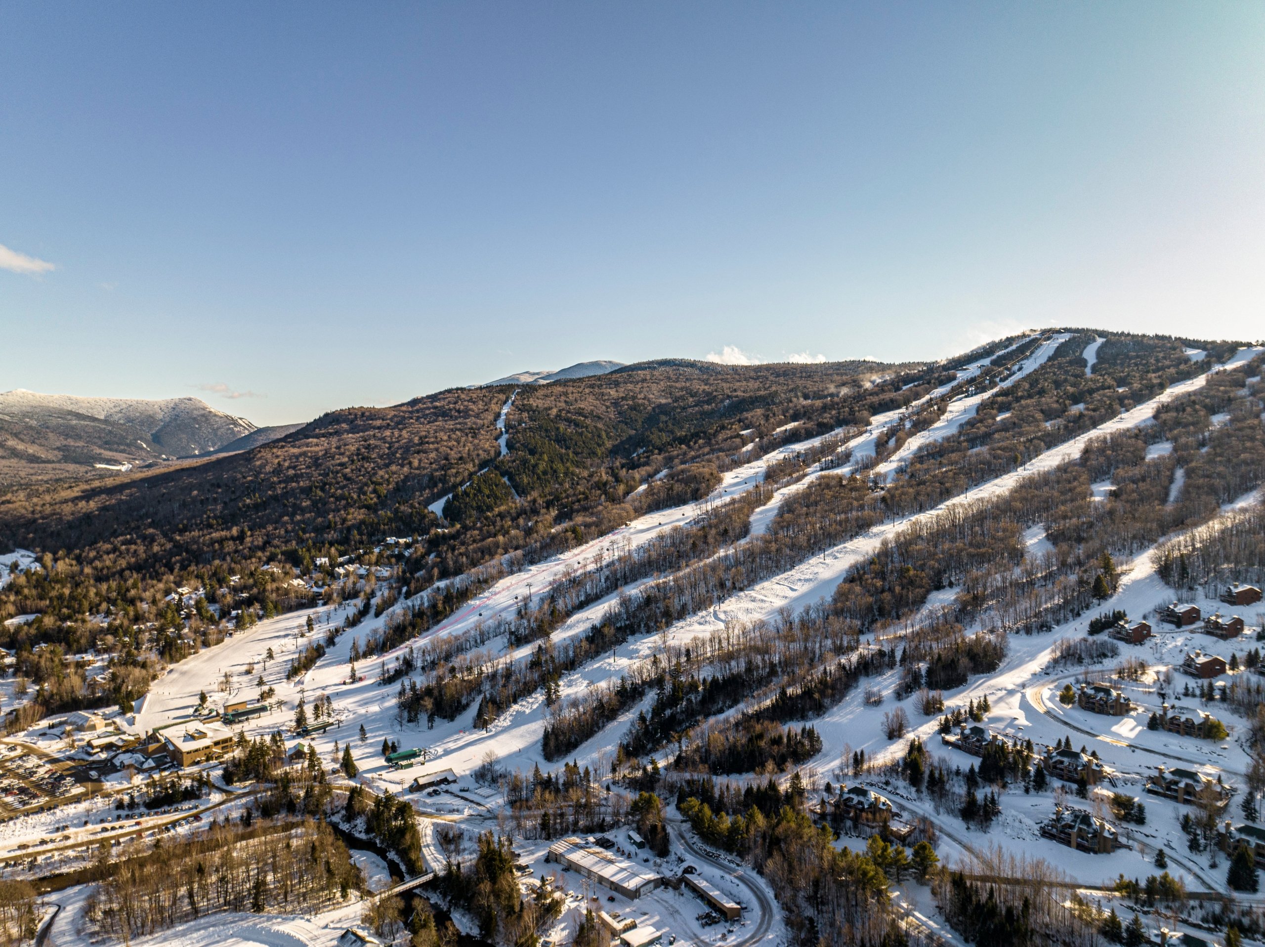 Aerial view of Bretton Woods Ski Area with multiple groomed trails winding down a forested mountain.