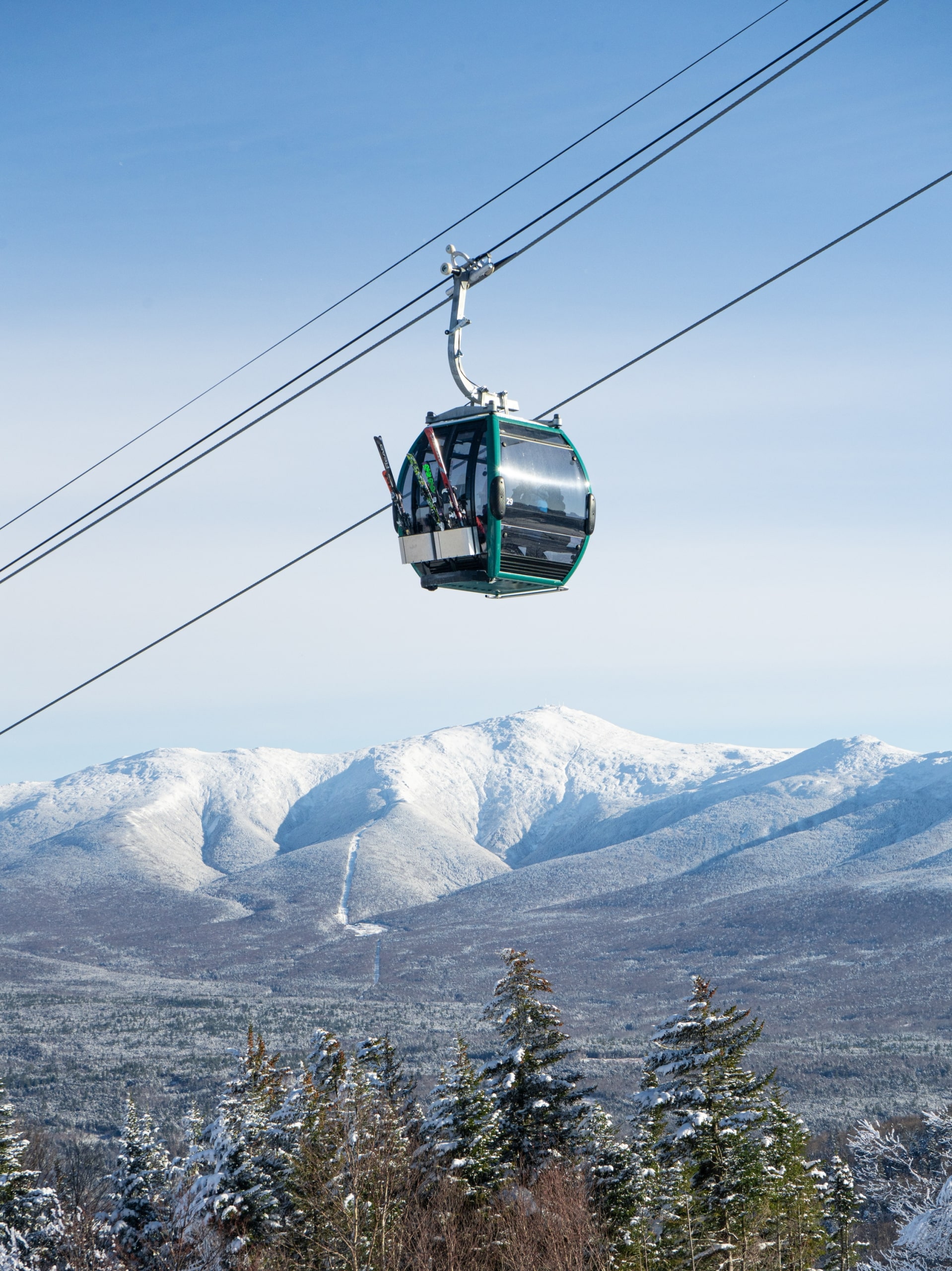 A ski gondola carries riders up a snowy mountain at Bretton Woods.