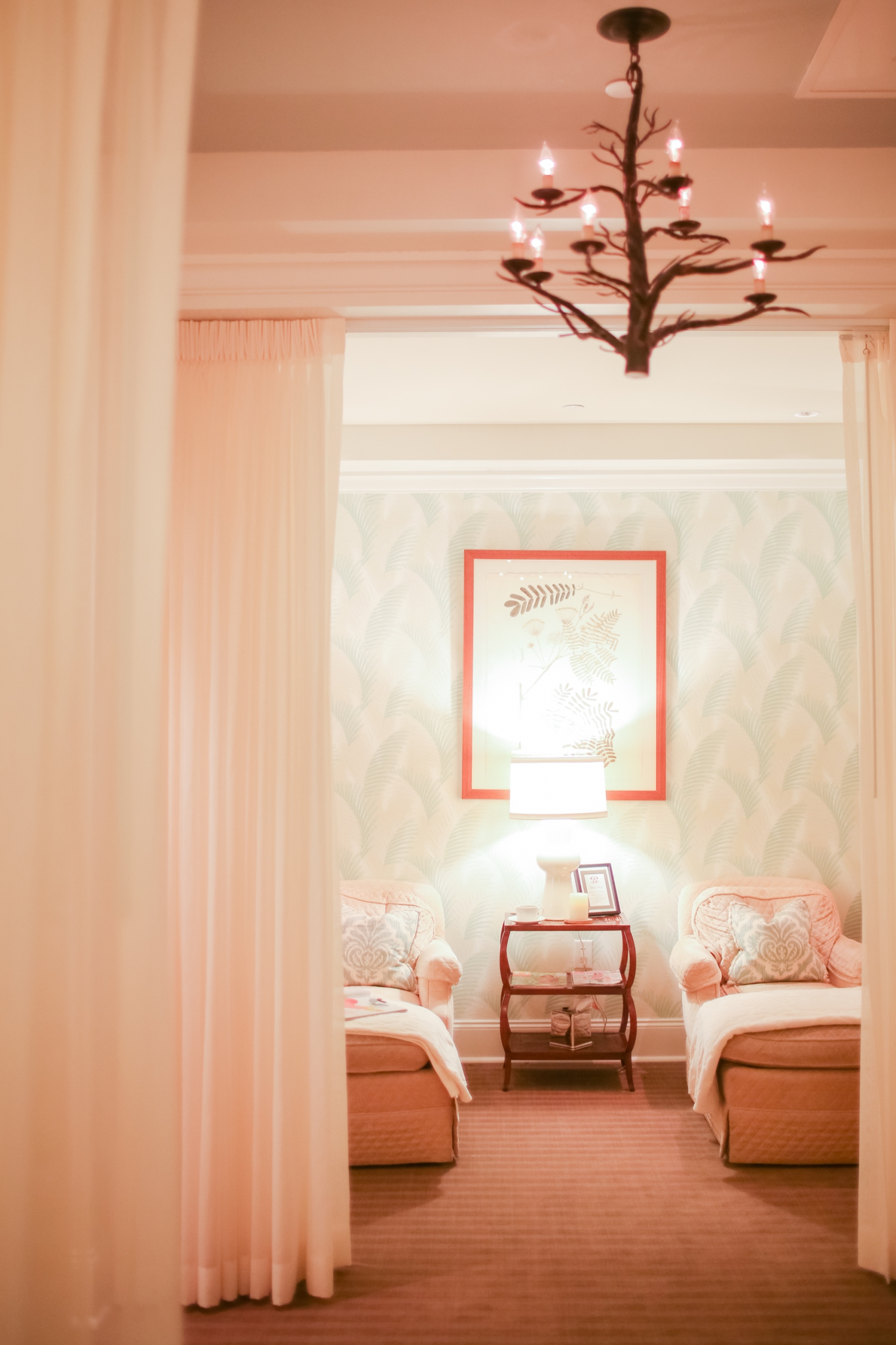 Cozy spa relaxation room with two cushioned chairs, soft lighting, and elegant decor behind sheer curtains at Mount Washington Resort and Spa.