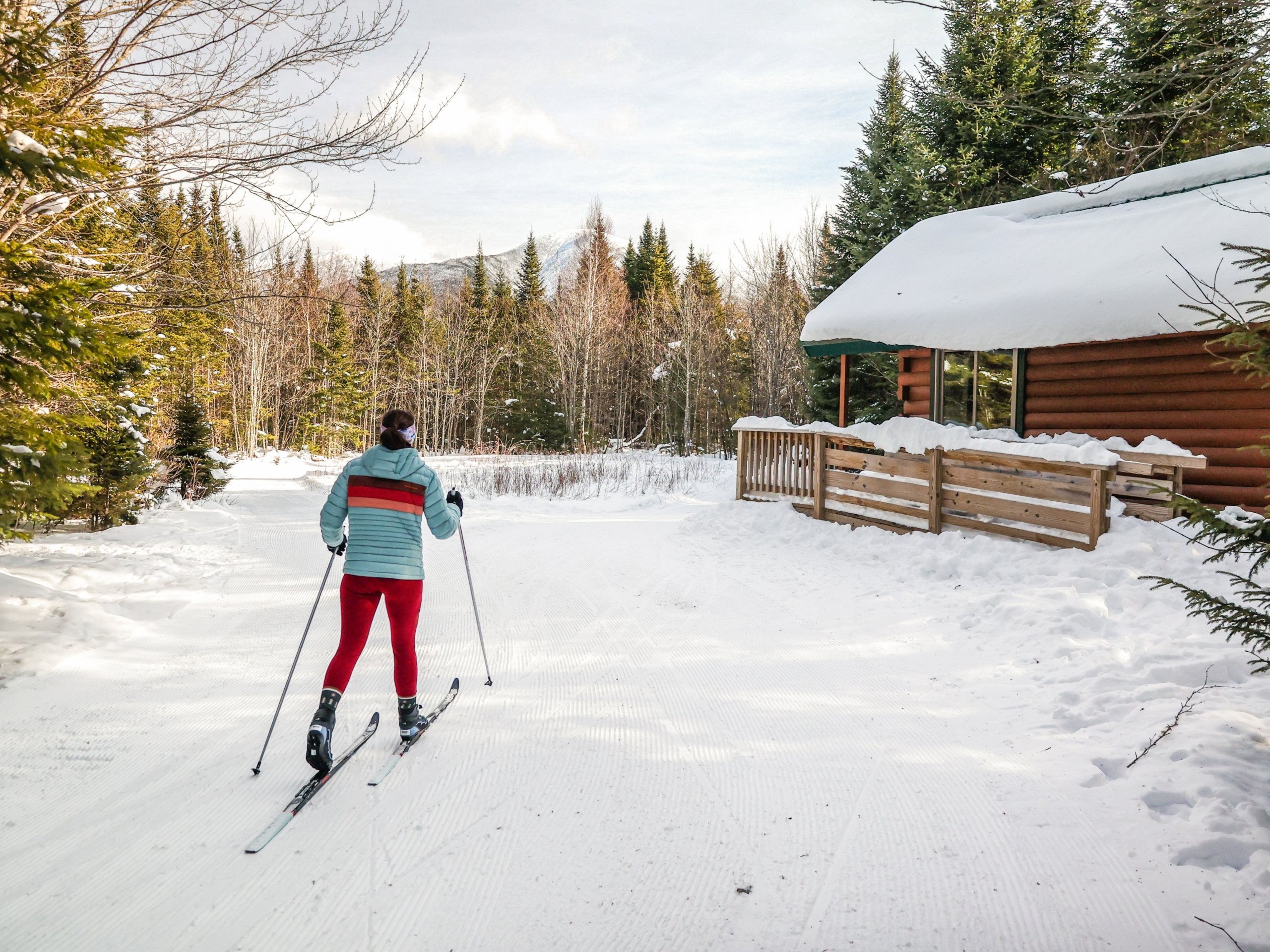 A cross-country skier glides through the snowy trails in the forest at Mount Washington Resort and Spa.