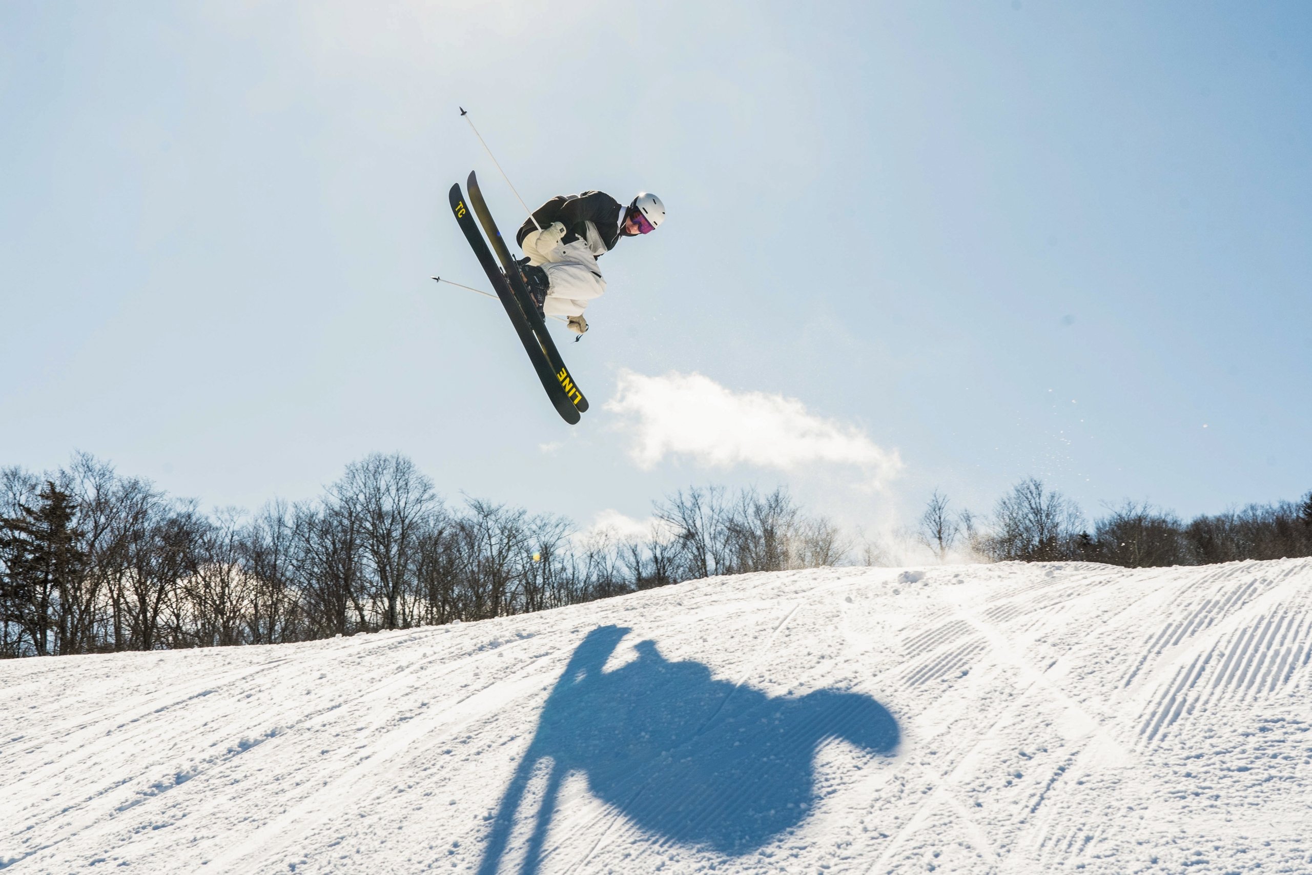 A skier performs a trick in the air on a sunny day on the ski hill at Bretton Woods.