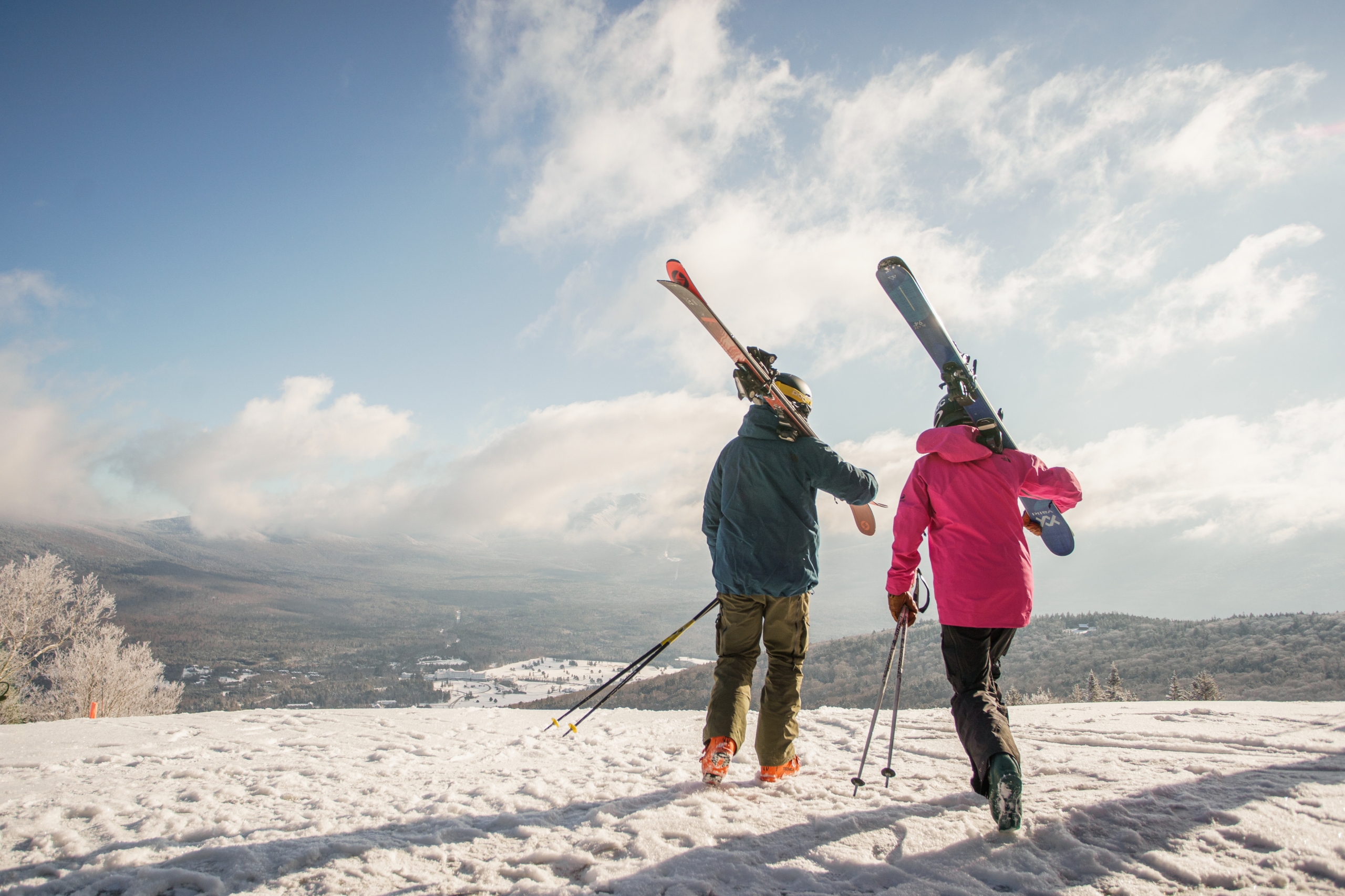 Two skiers carry their ski gear at the top of the mountain at Bretton Woods.