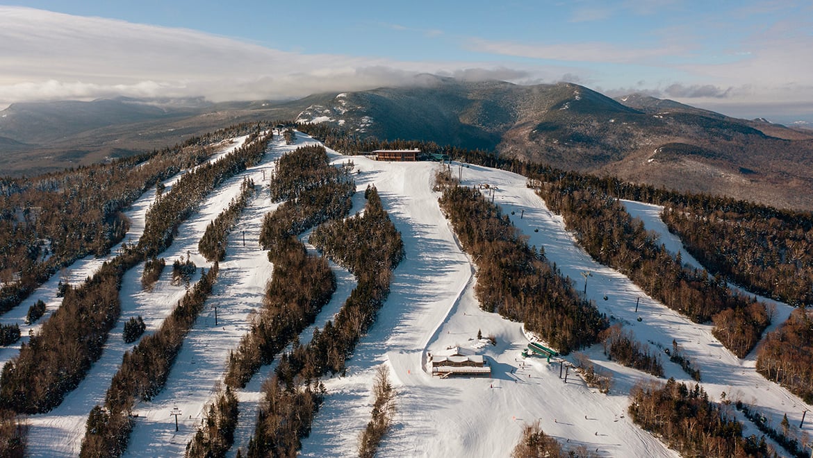 Aerial view of Bretton Woods Ski Area with multiple groomed trails winding down a forested mountain.