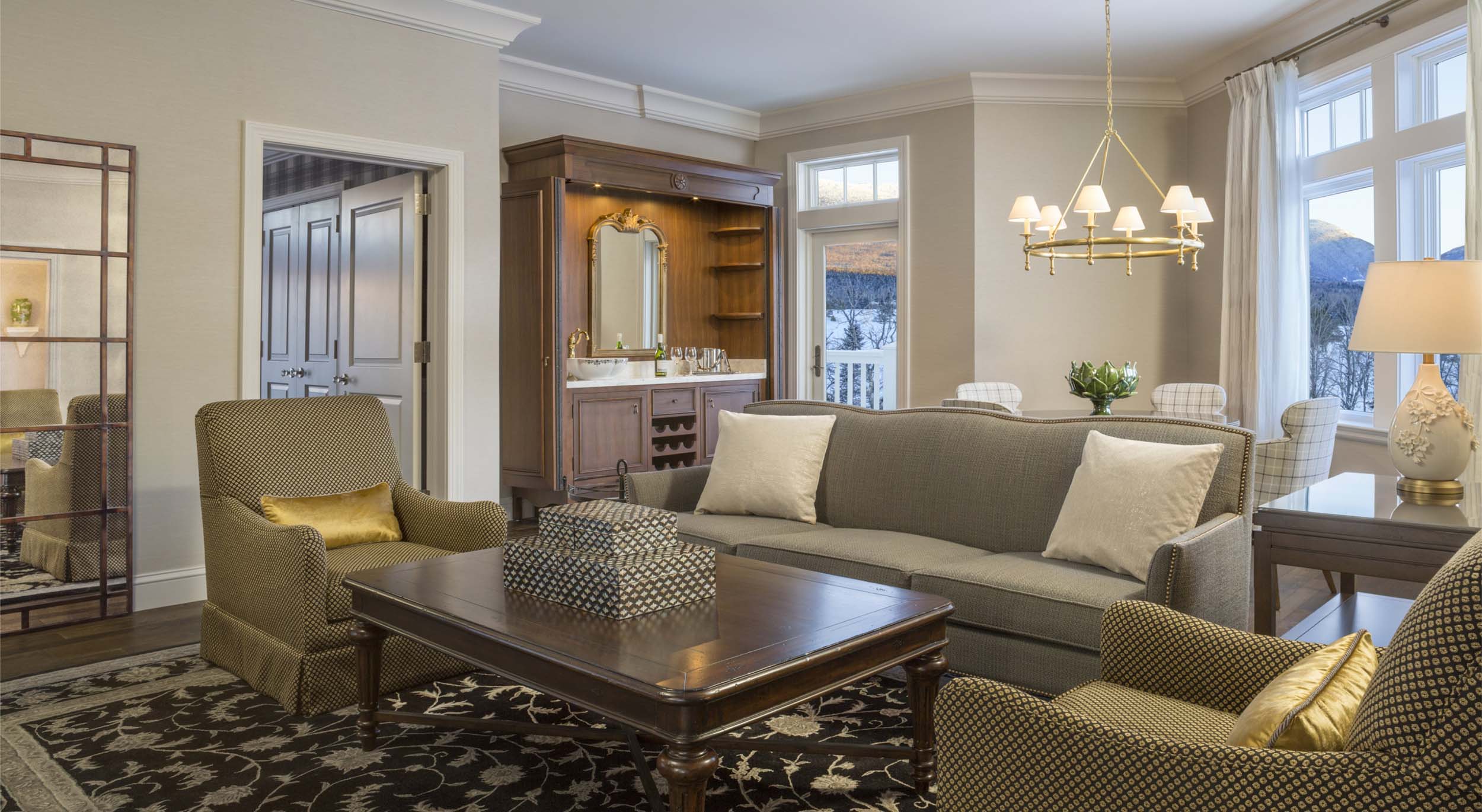 The Executive Presidential Suite at Mount Washington Resort and Spa features a comfortable living area with plush seating, a dining table and bar.