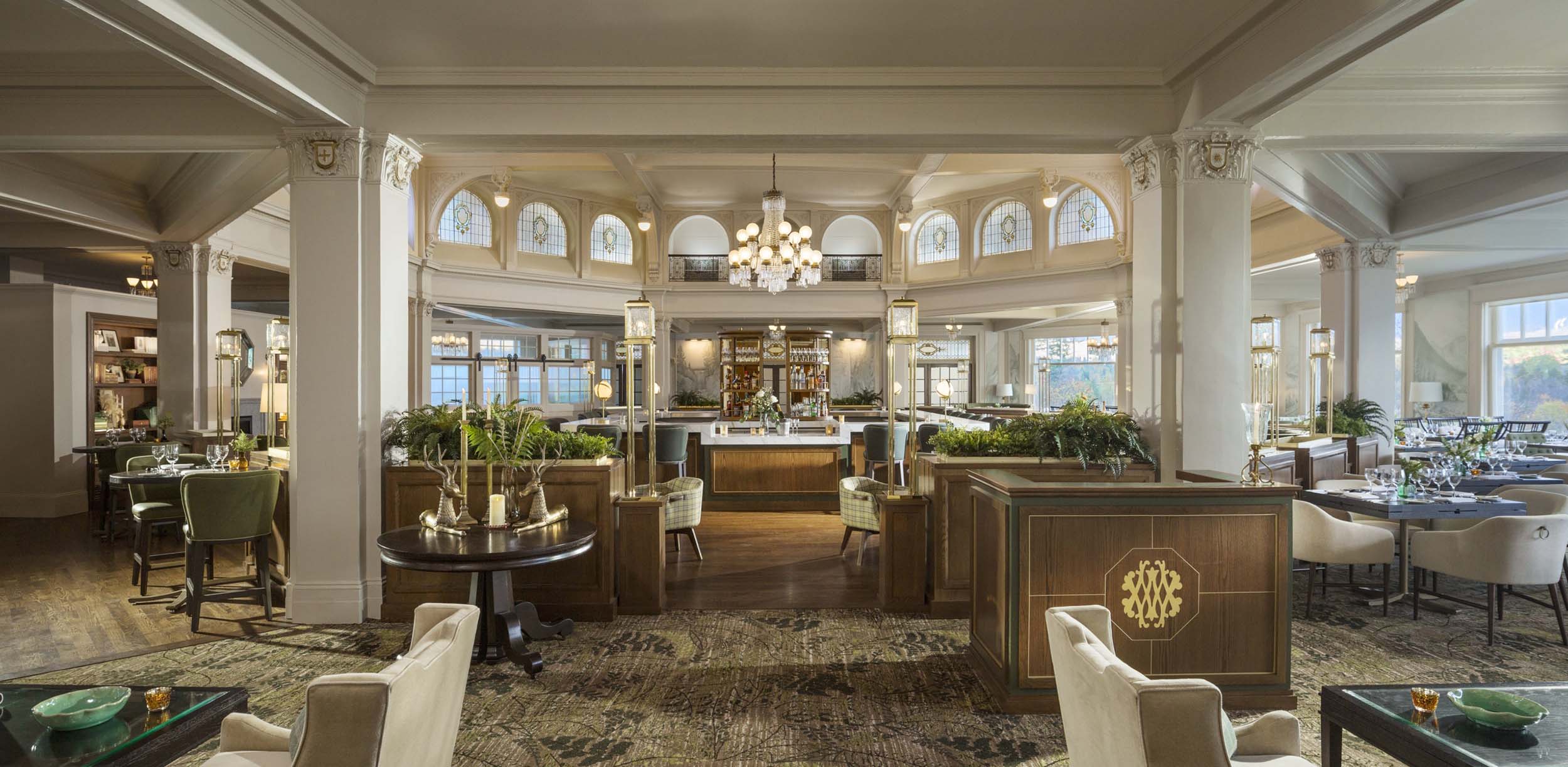 Elegant restaurant dining room with classic architecture, chandeliers, and sophisticated seating arrangements at Mount Washington Resort and Spa.