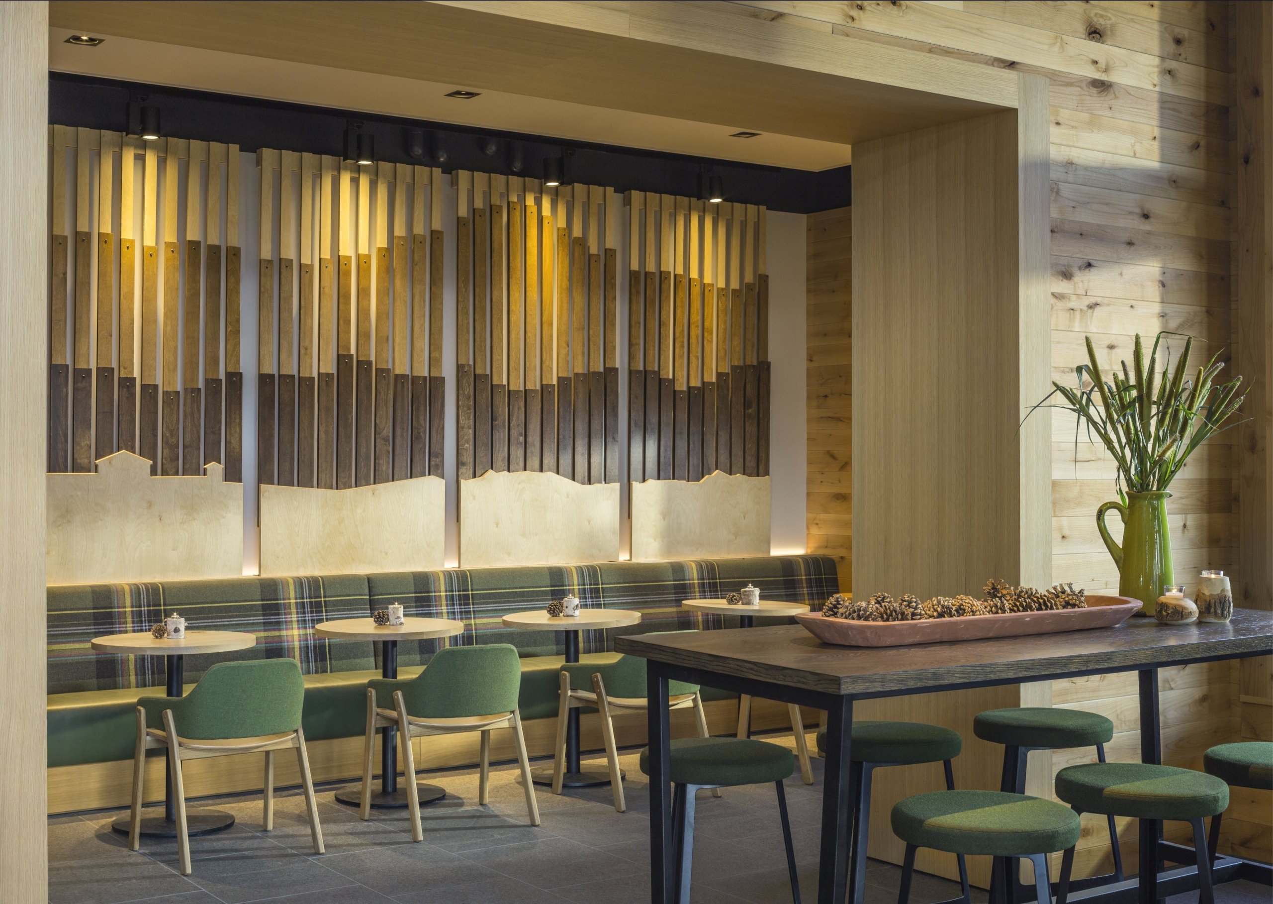 Peaks Café features wooden walls, green chairs, and warm lighting.