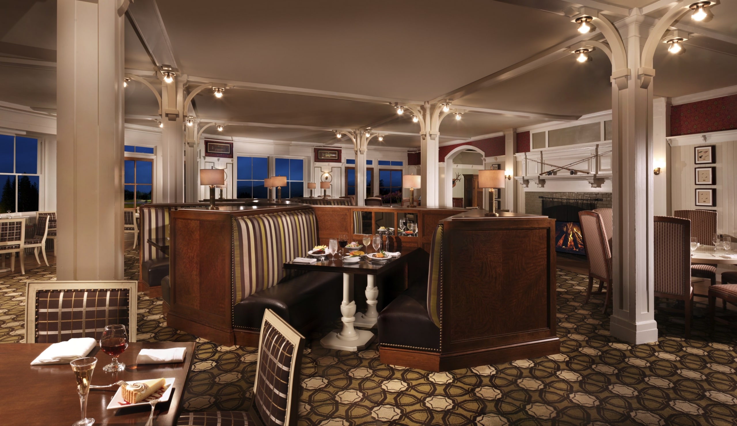 A cozy dining room with a mix of tables and booths at Stickneys Restaurant at Mount Washington Resort and Spa.
