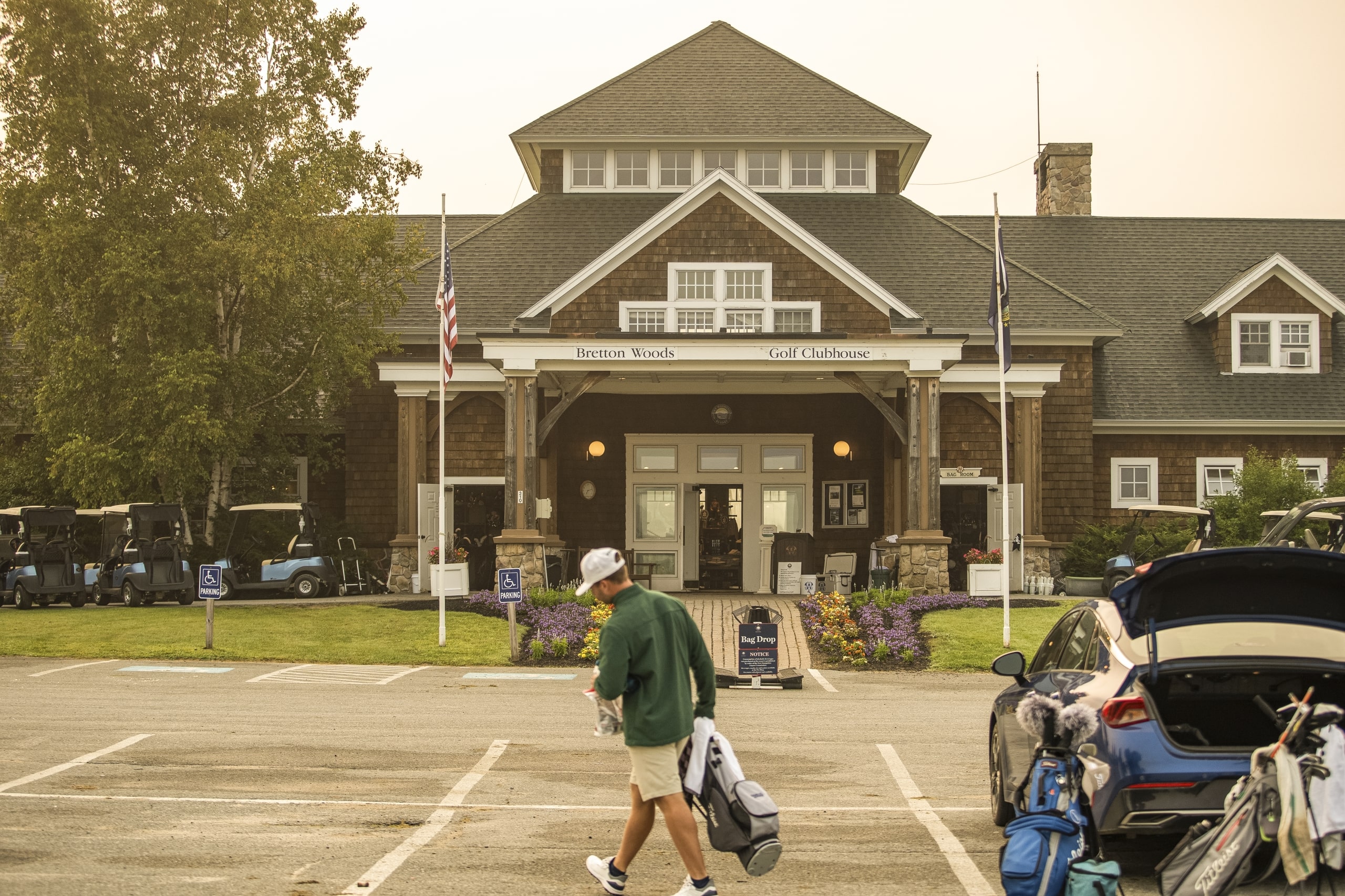 A golfer unloads his golf clubs from his car in front of the Bretton Woods Golf Clubhouse.