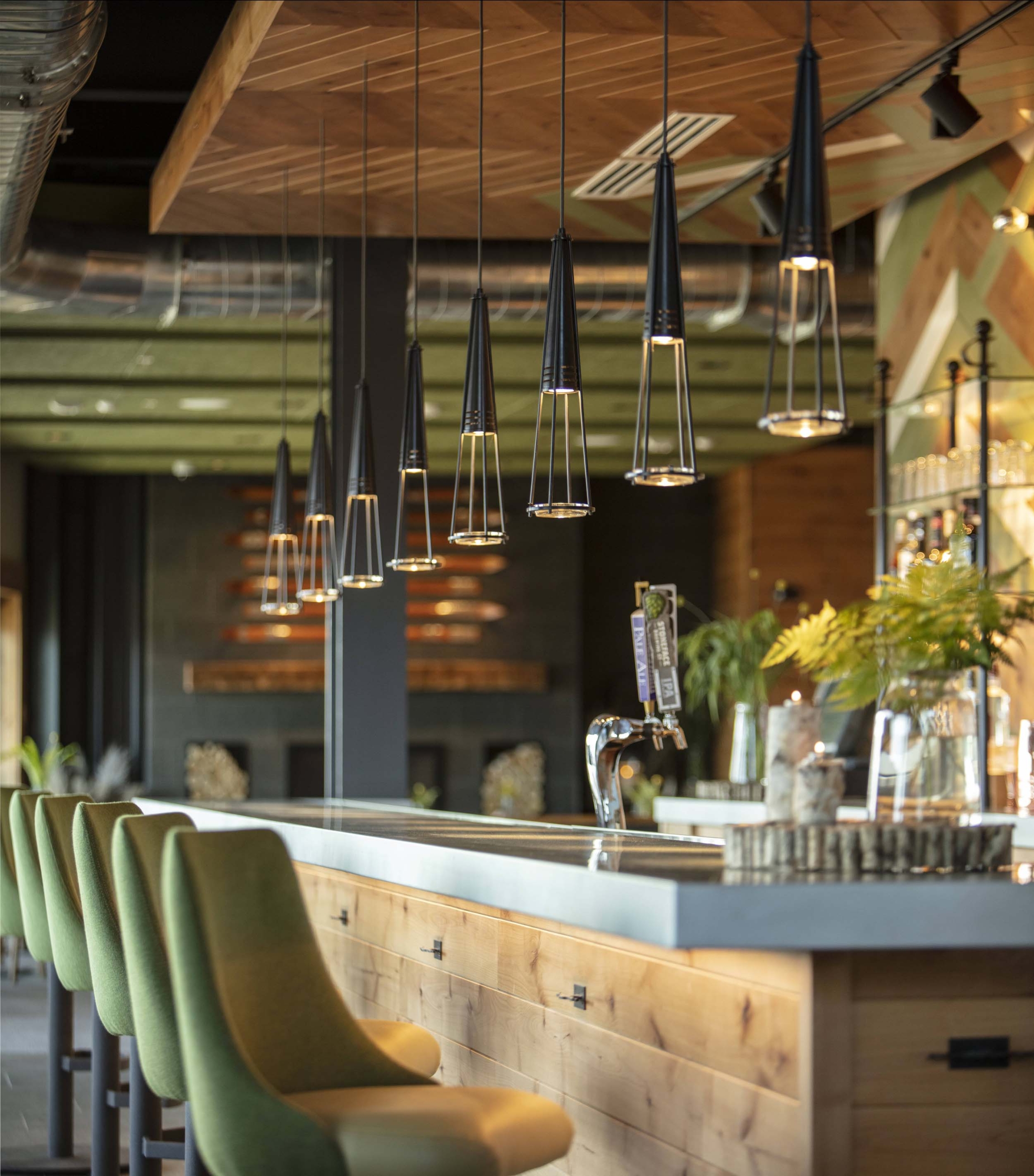 A close-up of green chairs lined up at the bar at Switchback Grille.