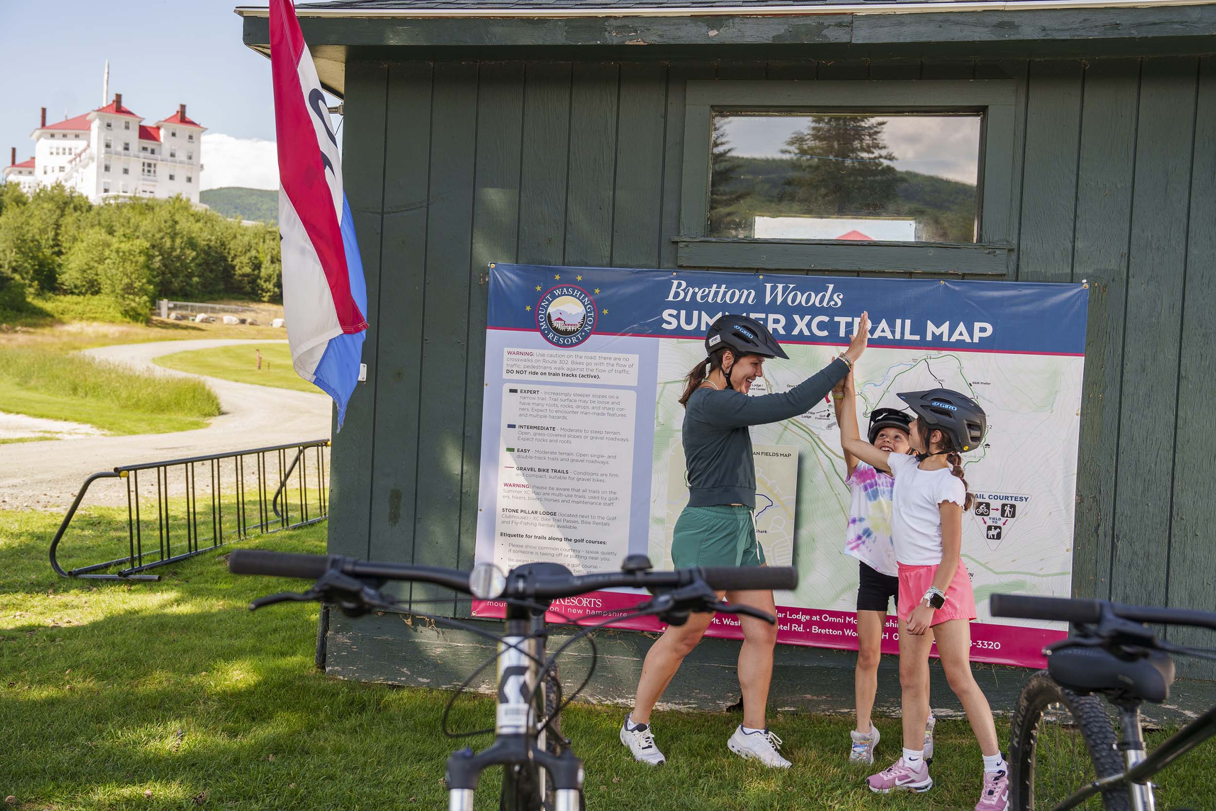 Kids high-five near their parked mountain bikes.