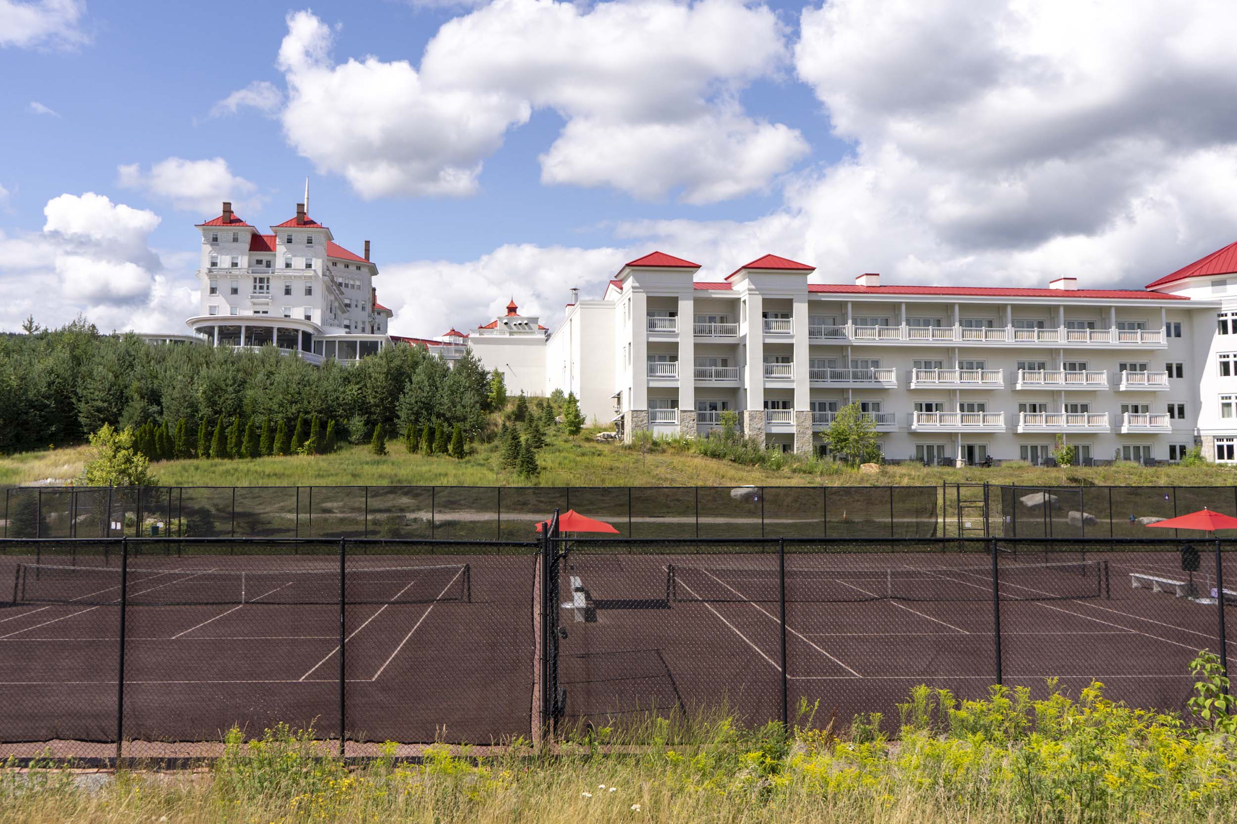 A view out over the tennis court boundary with OMNI Mount Washington Resort and Spa in the background