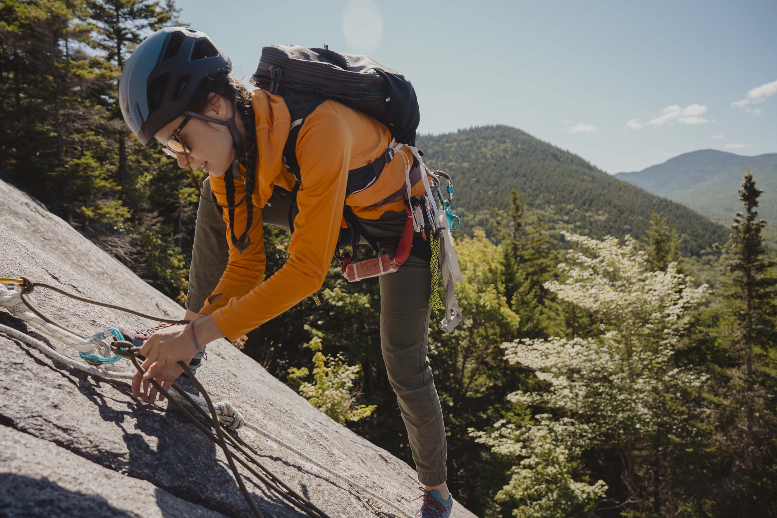 A rock climber clips in on the West Wall on Mount Washington