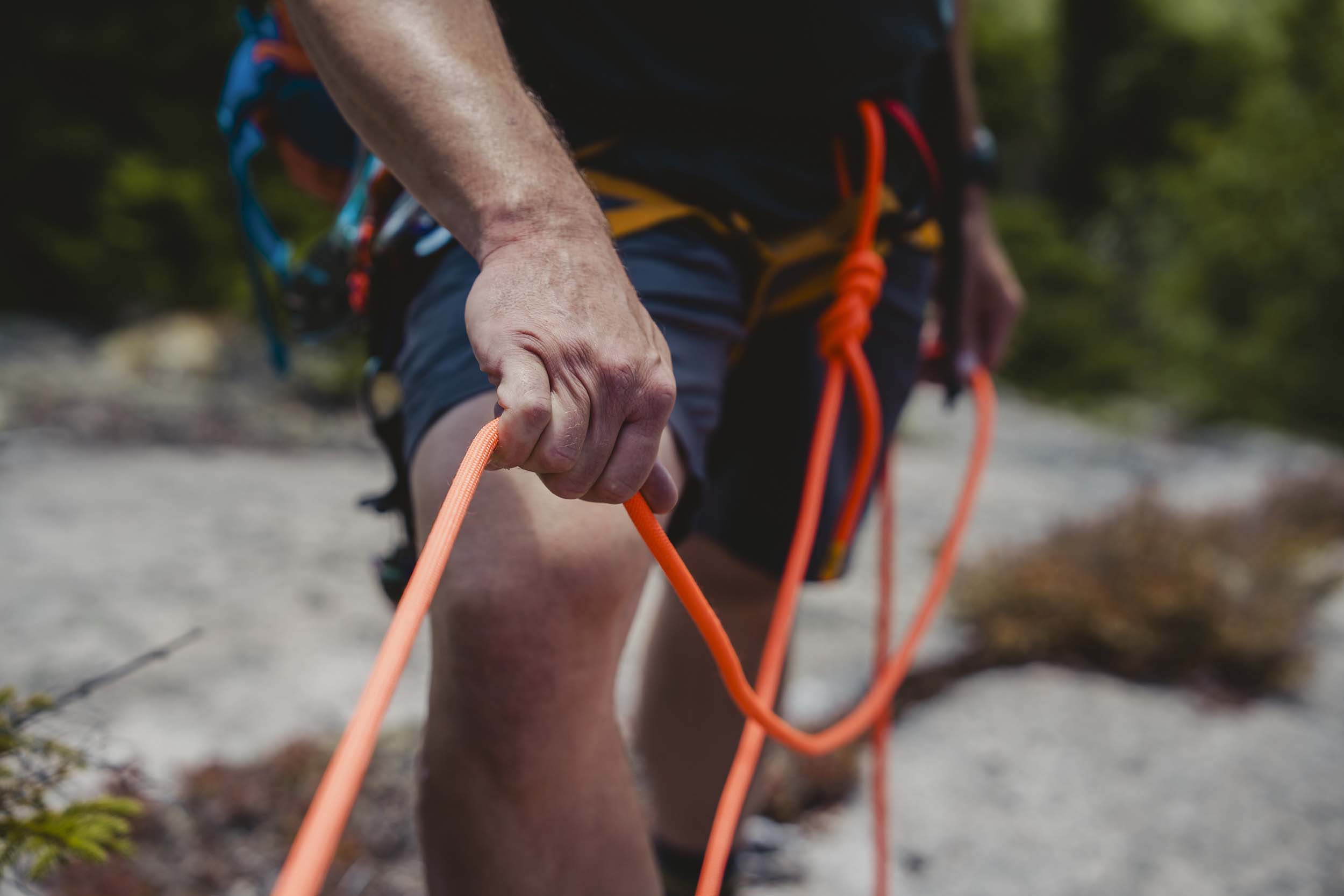 A close-up of a rock climbers holding the rope as they climb on the West Wall at Bretton Woods