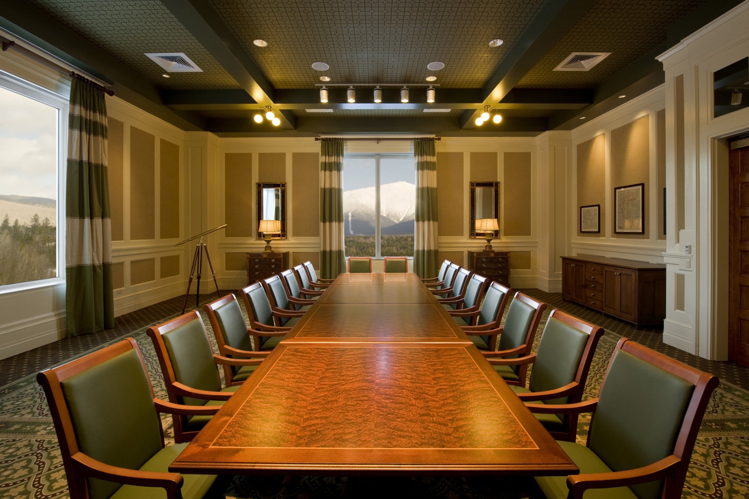 A boardroom with a long conference table, office chairs, and large windows at Mount Washington Resort and Spa.