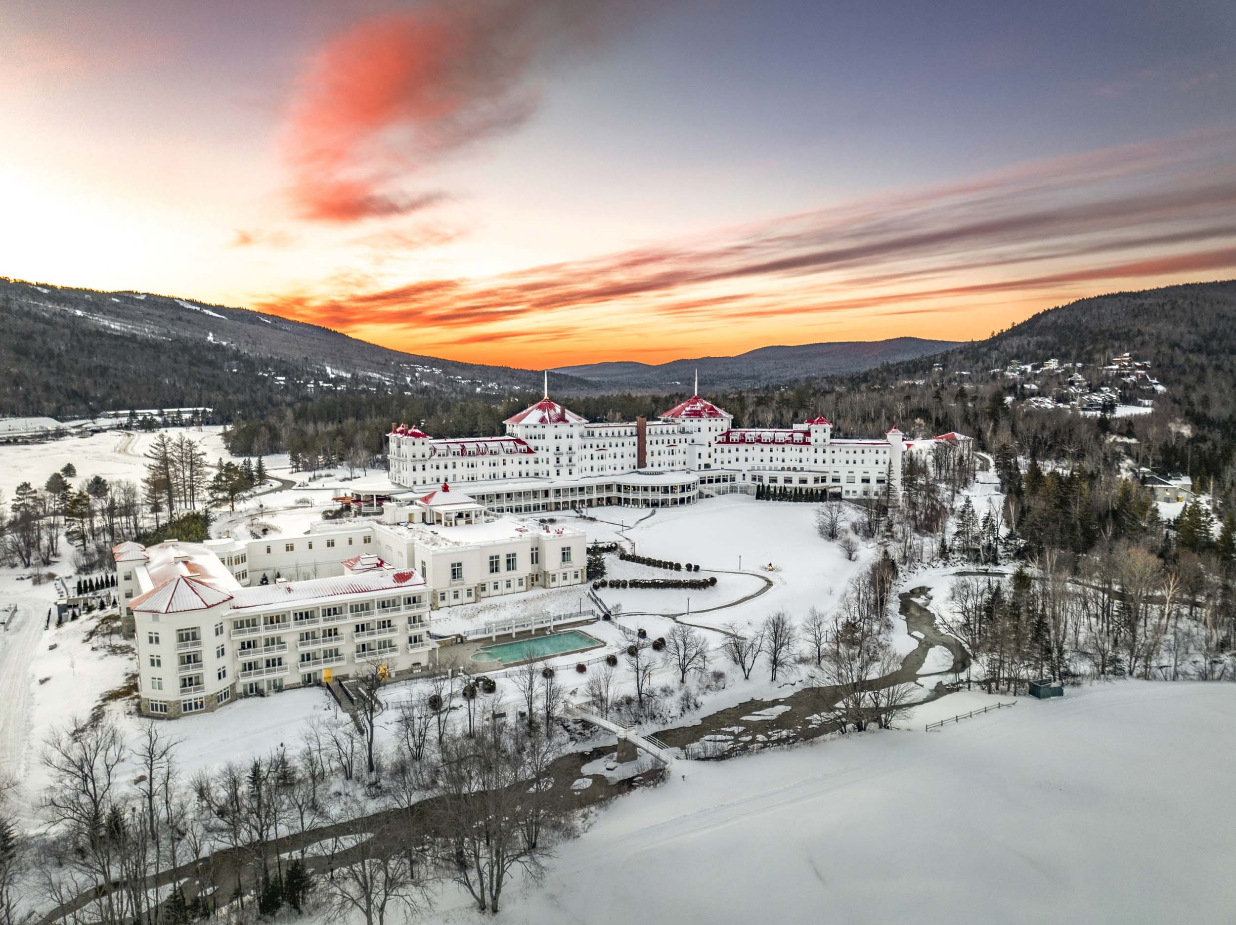 Mount Washington Resort and Spa sits nestled among snow-covered grounds at sunset.