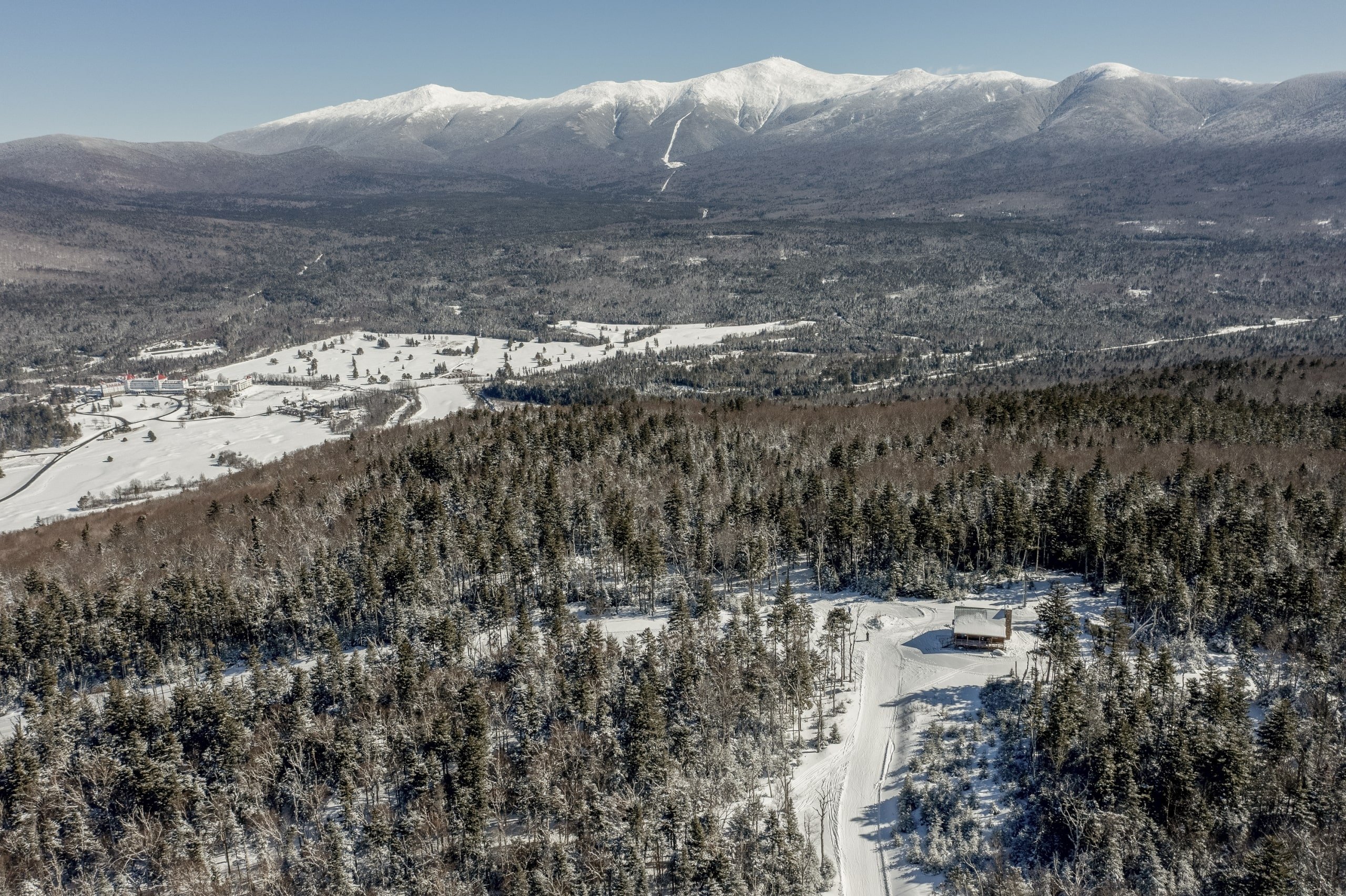 A snowy ski hill with a tall mountain range at Bretton Woods.