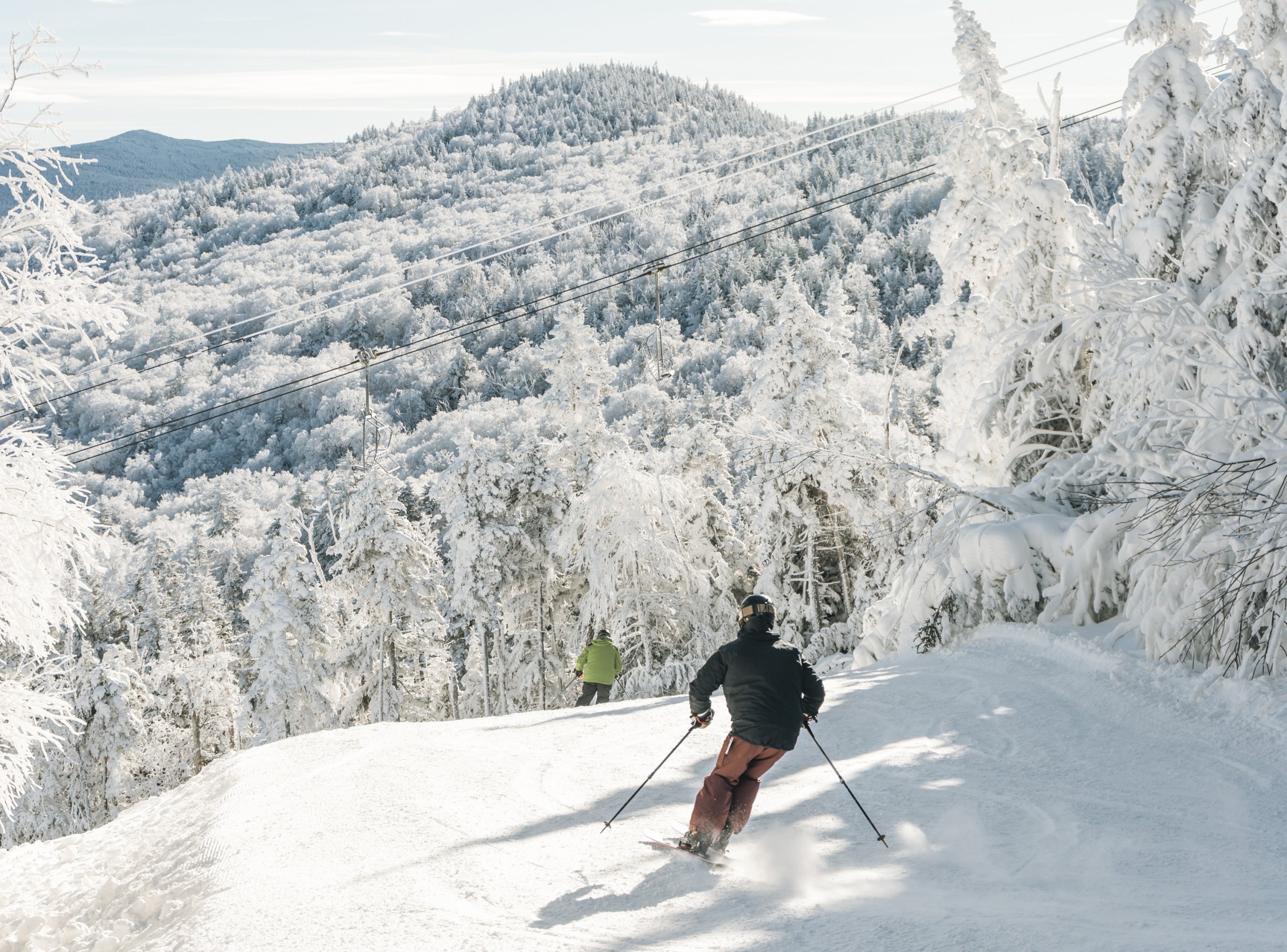 Two skiers glide down a snowy slope at Bretton Woods.
