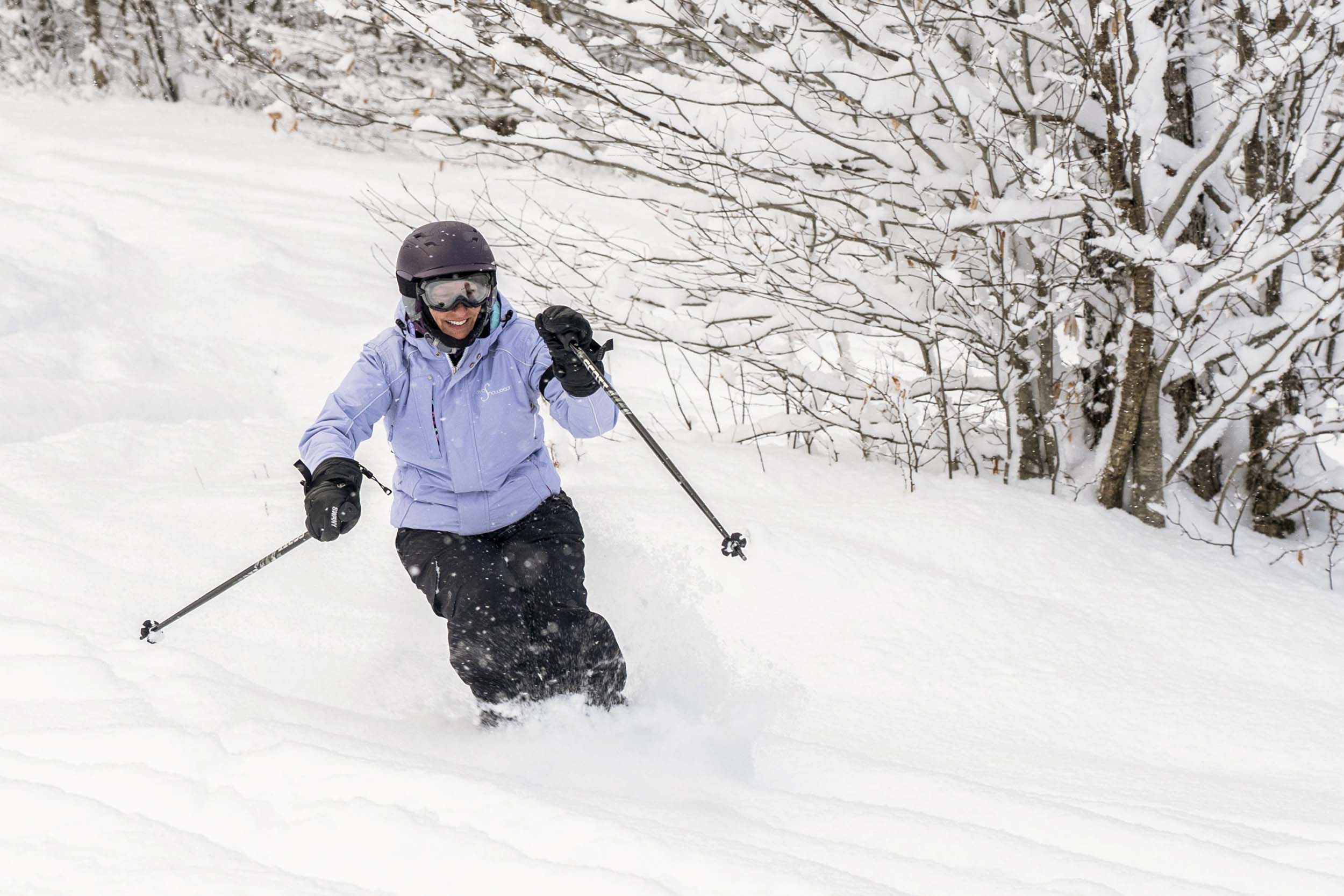 A woman skis down a deep powder slope at Bretton Woods.