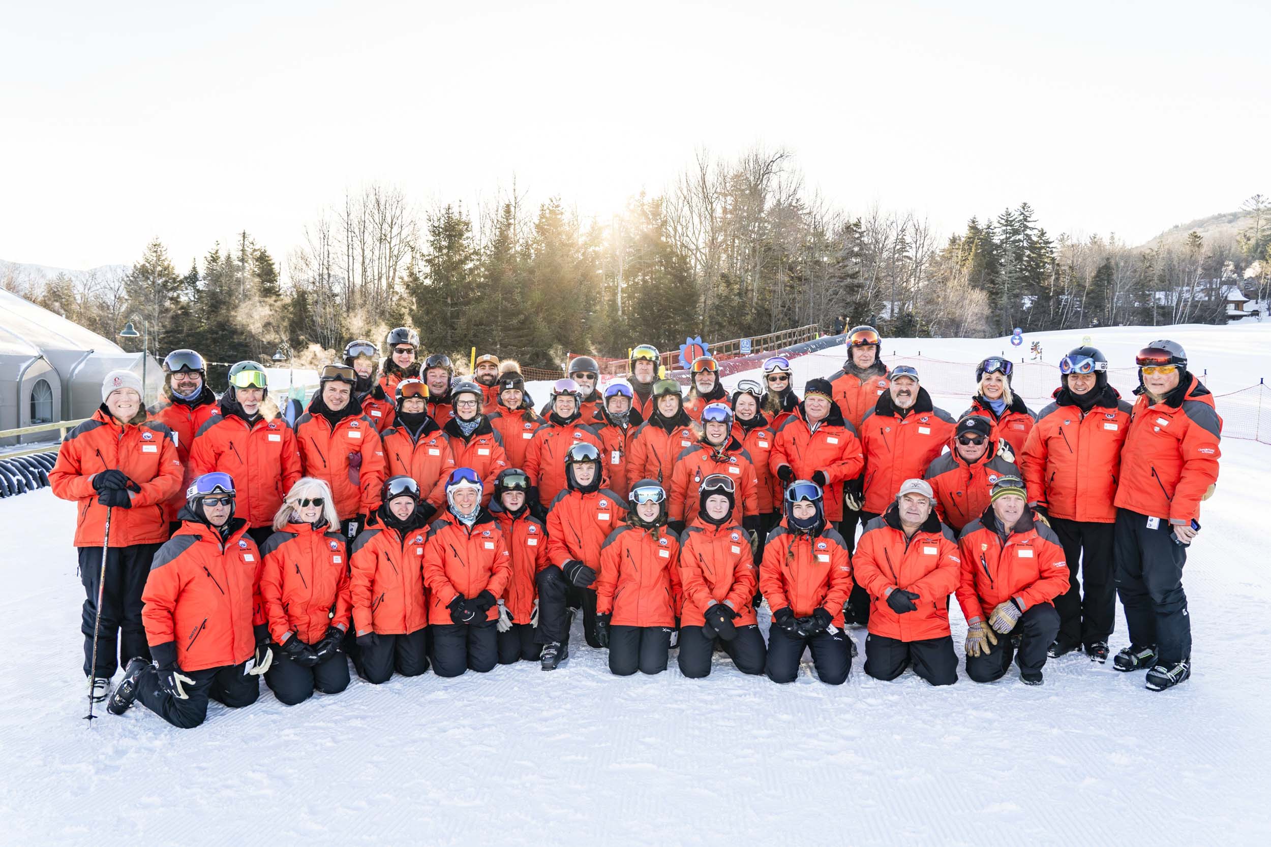A team of ski instructors gather in their gear for a group photo in the snow at Bretton Woods.