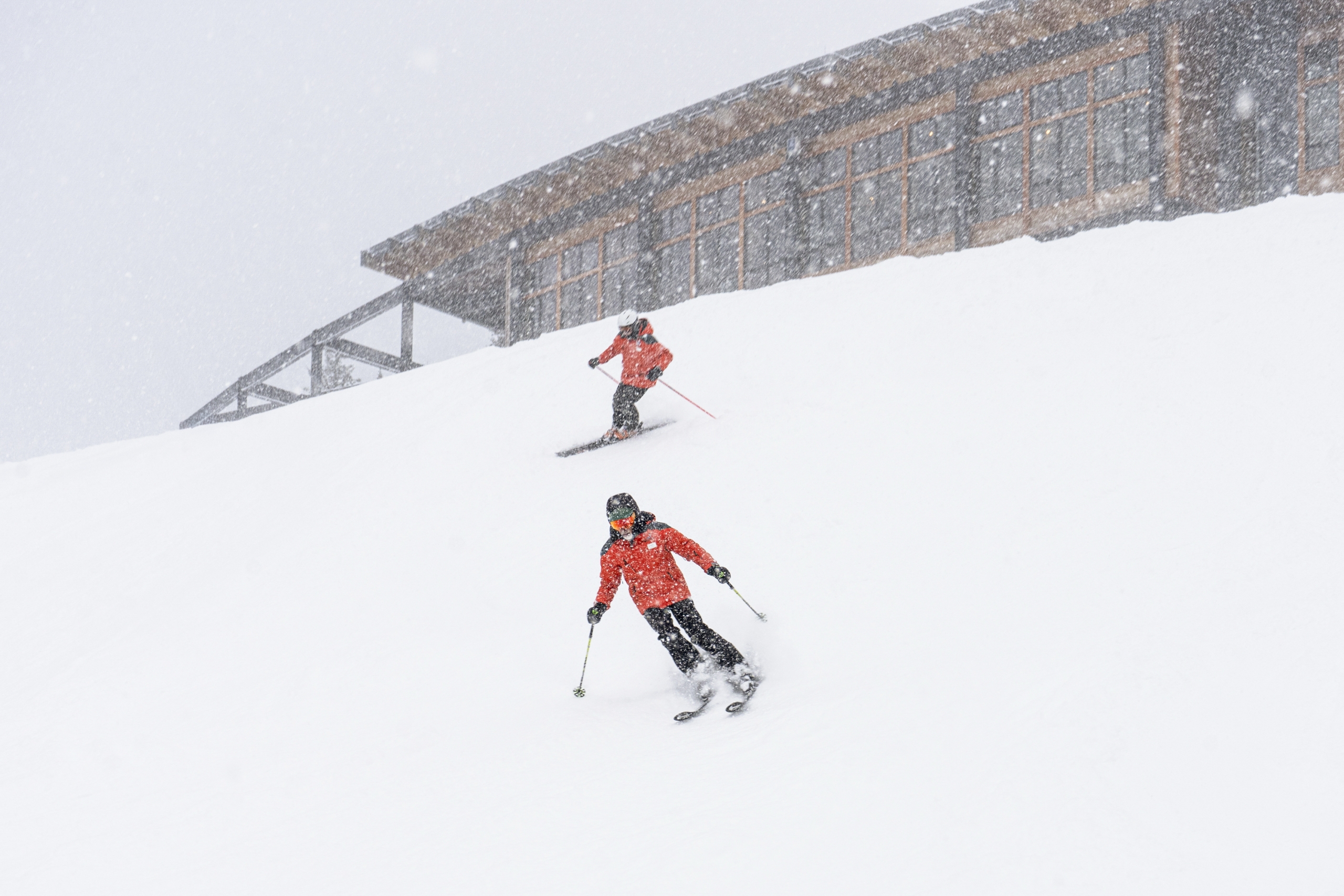 Two skiers glide down a snowy slope during a snowstorm at Bretton Woods.