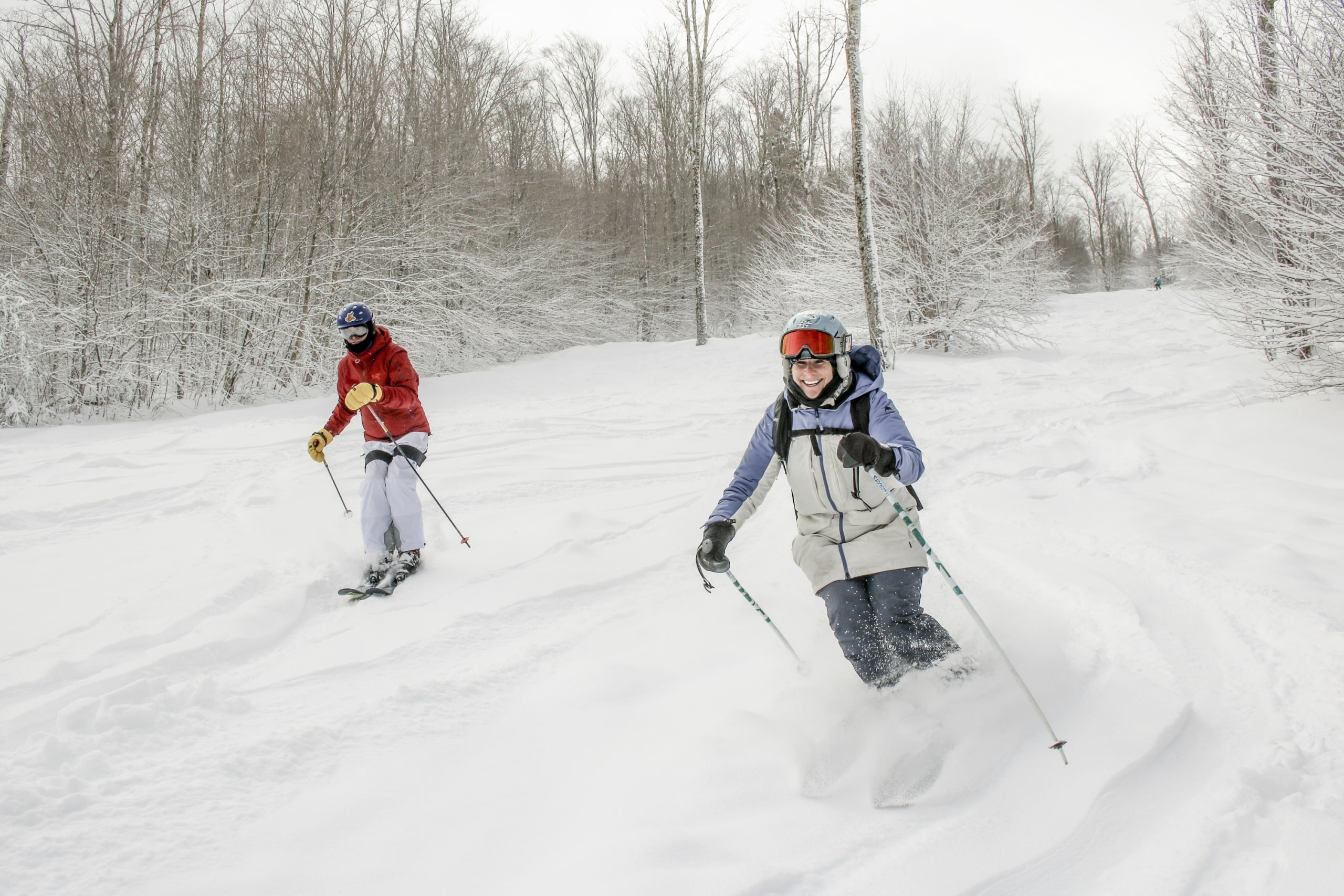 Two skiers joyfully glide through the powdery snow at Bretton Woods.