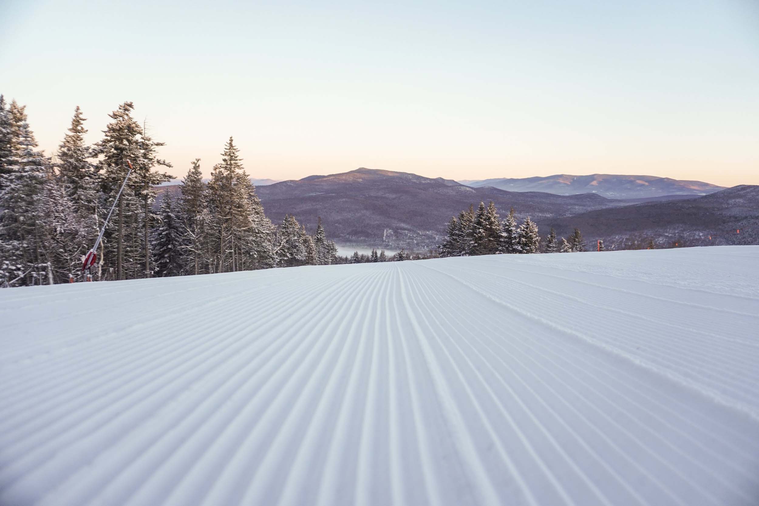 Freshly groomed snow run at sunrise