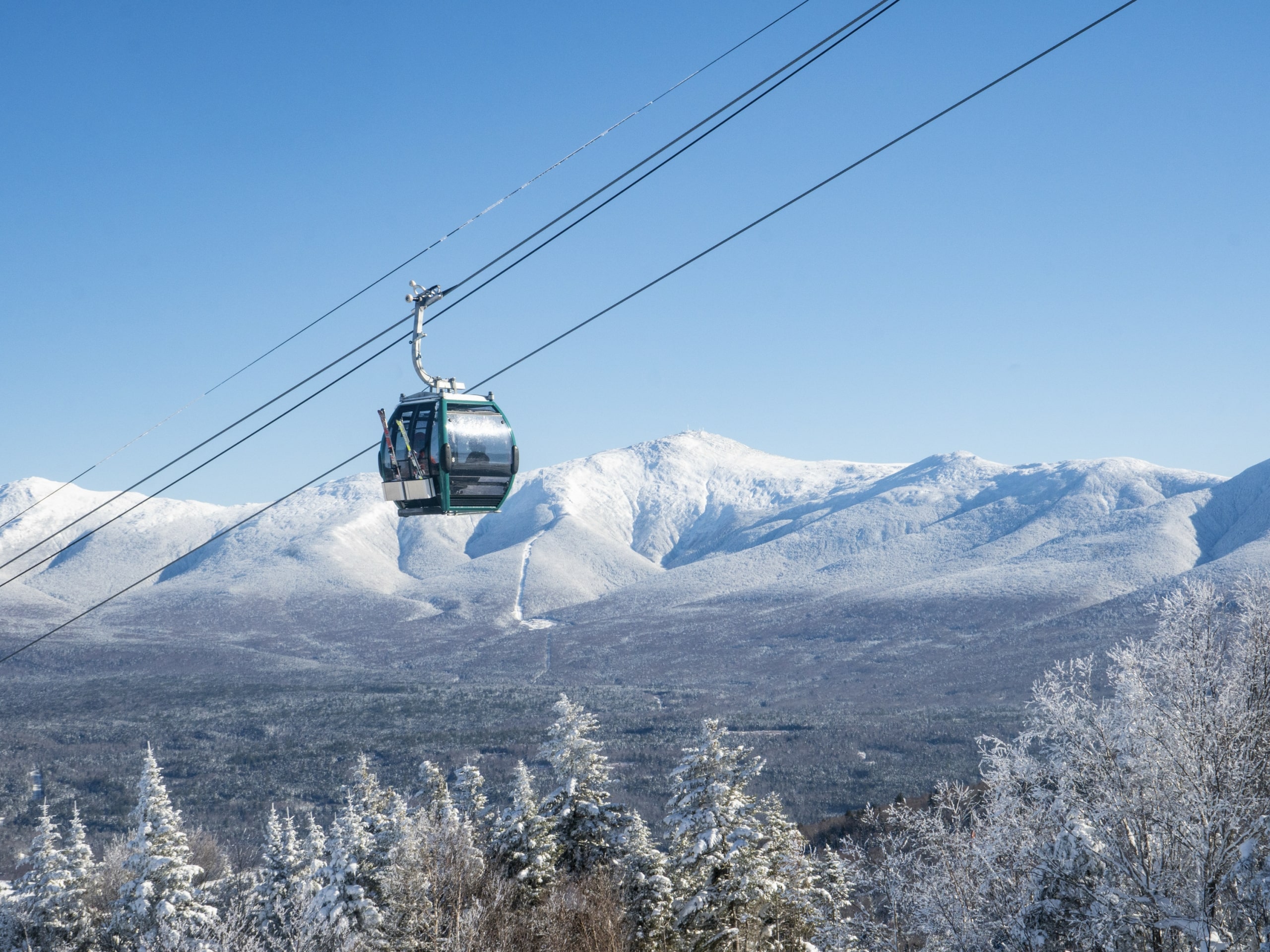 A ski gondola carries riders up a snowy mountain at Bretton Woods.