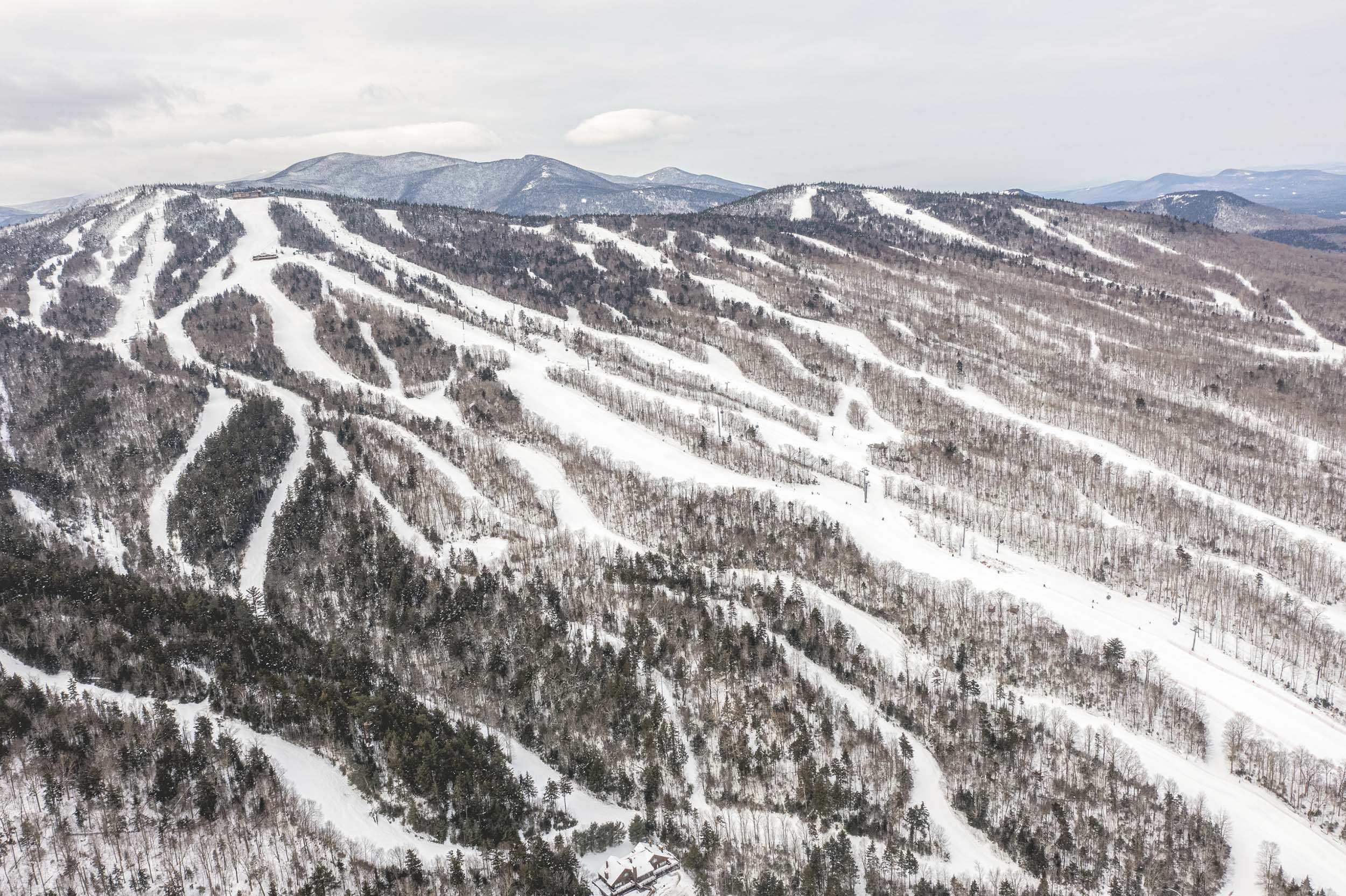 Aerial view of Bretton Woods Ski Area with multiple groomed trails winding down a forested mountain.