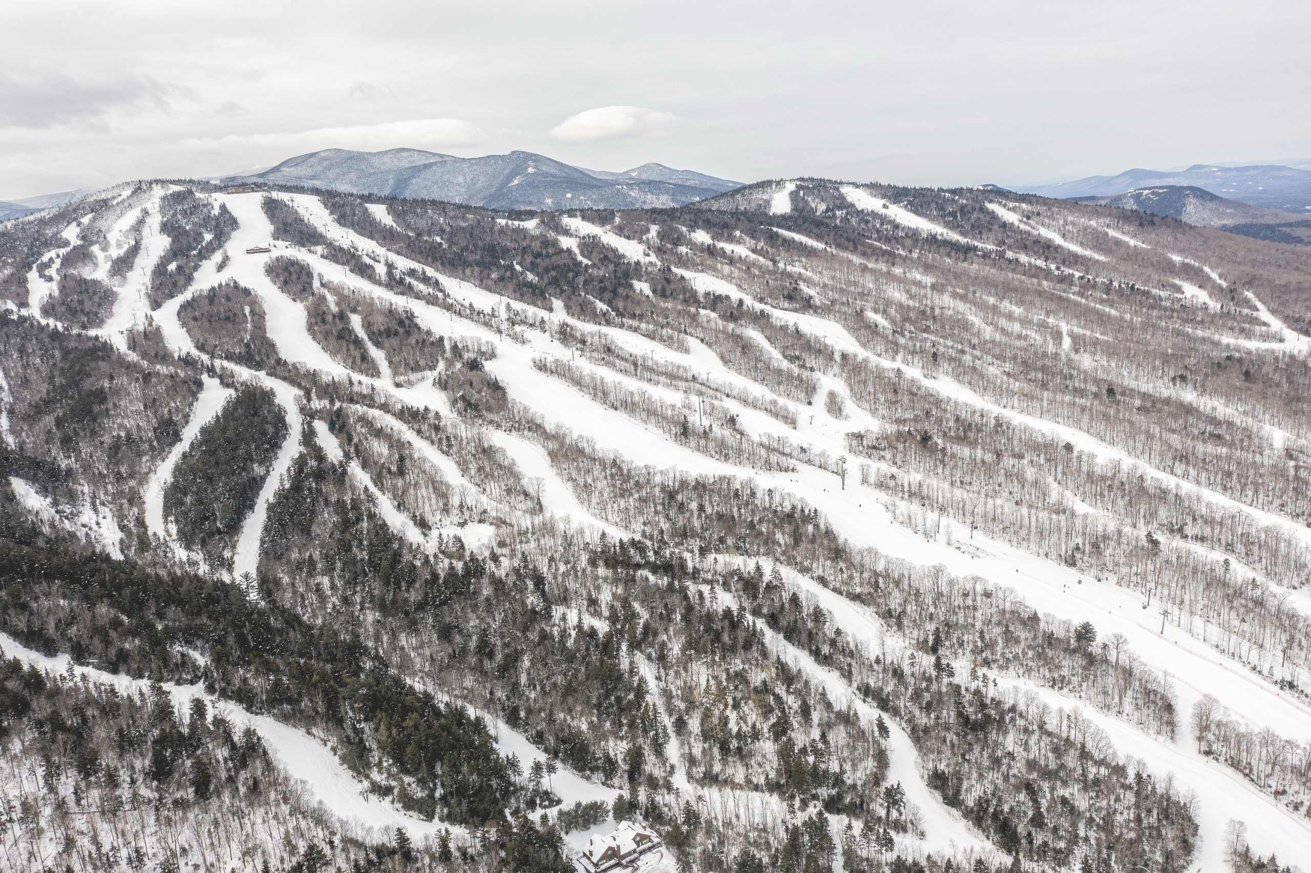 Aerial view of Bretton Woods Ski Area with multiple groomed trails winding down a forested mountain.