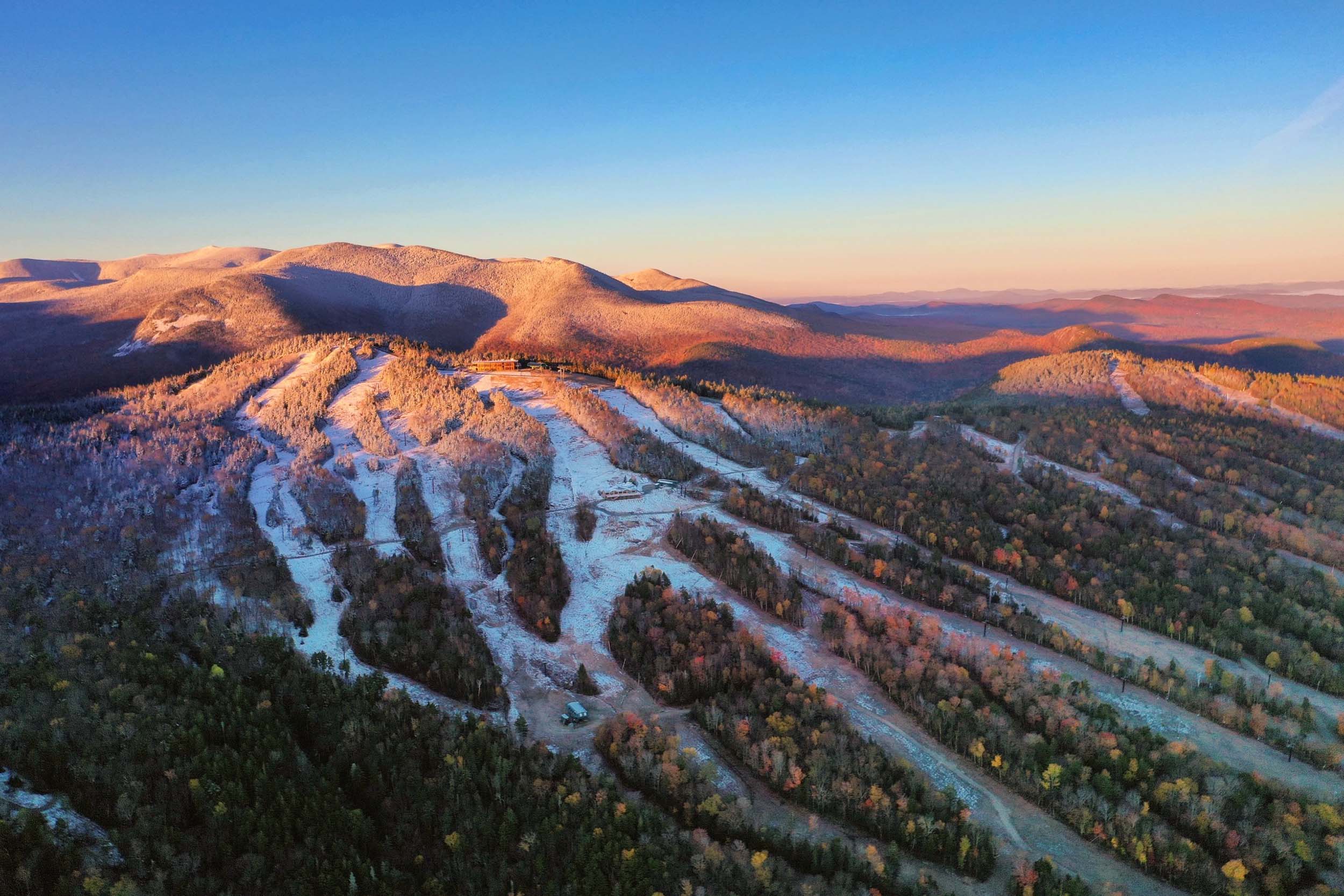 The sun sets over the snowy trails nestled amongst the trees at Bretton Woods.