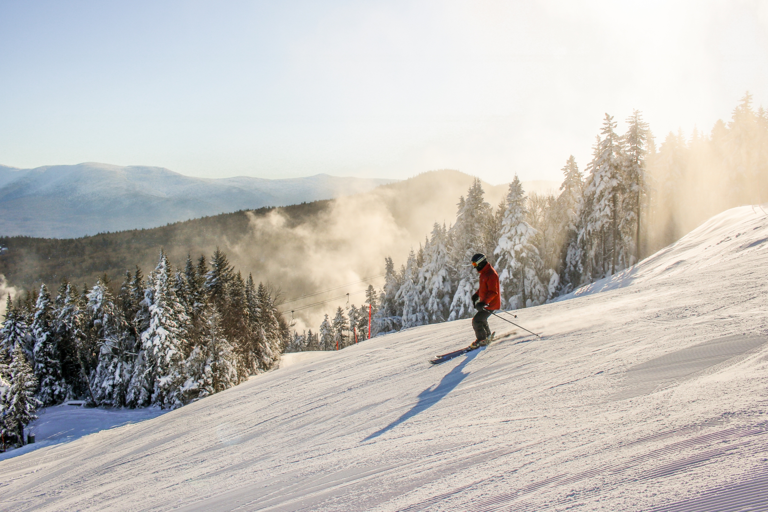 A skier glides down the snowy hill on a sunny day at Bretton Woods.