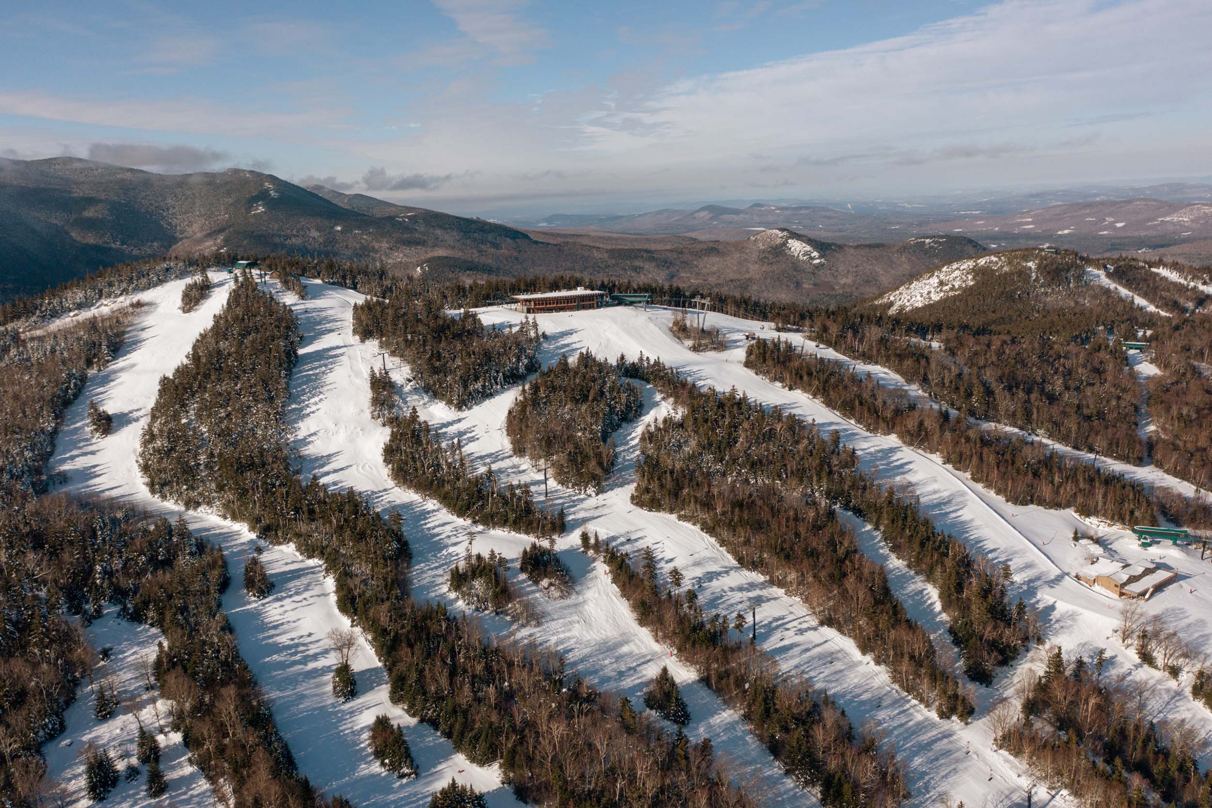 Aerial view of Bretton Woods Ski Area with multiple groomed trails winding down a forested mountain.