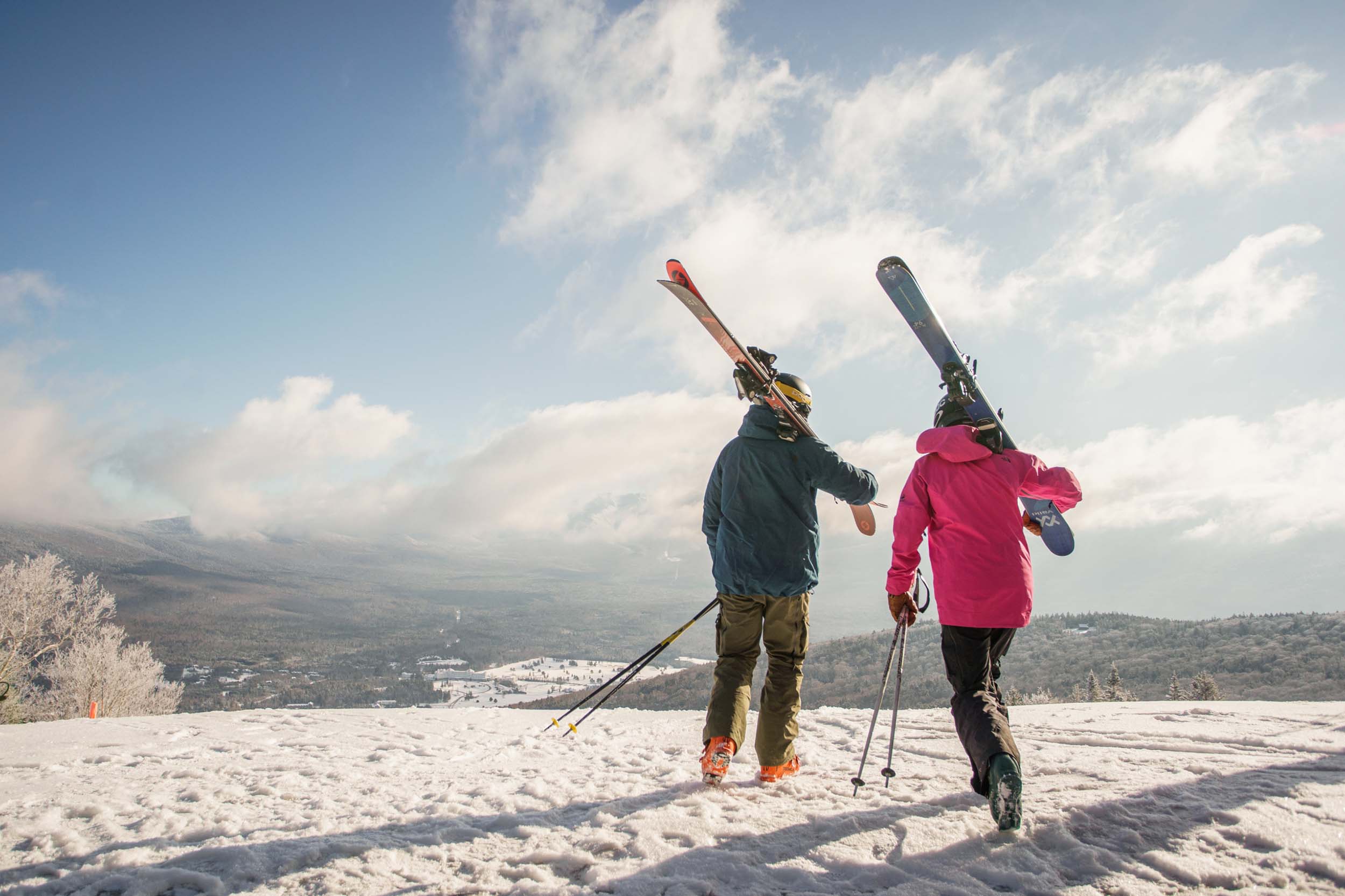 Two skiers carry their ski gear at the top of the mountain at Bretton Woods.