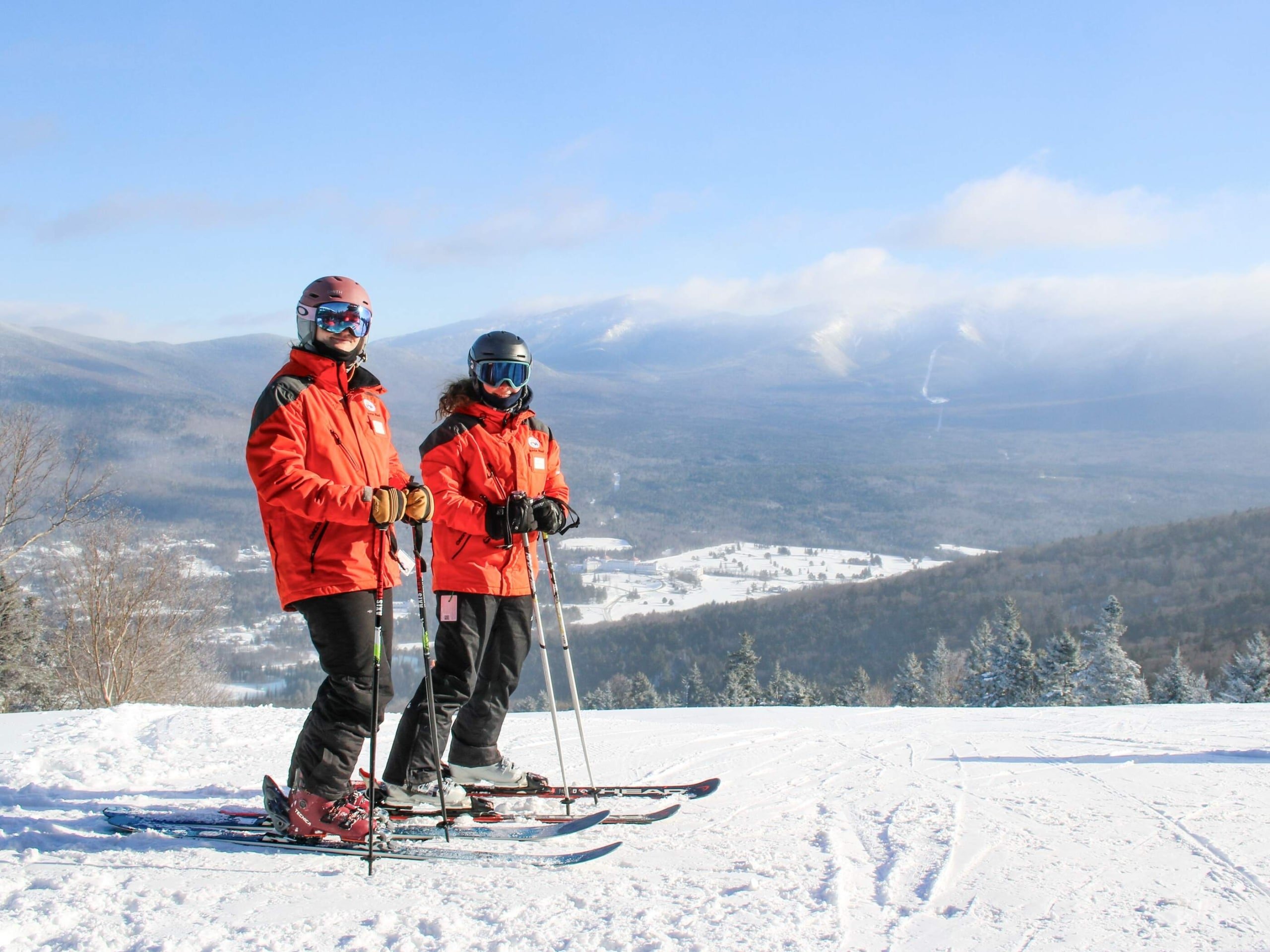 Two ski instructors stand at the top of snowy mountain at Bretton Woods.