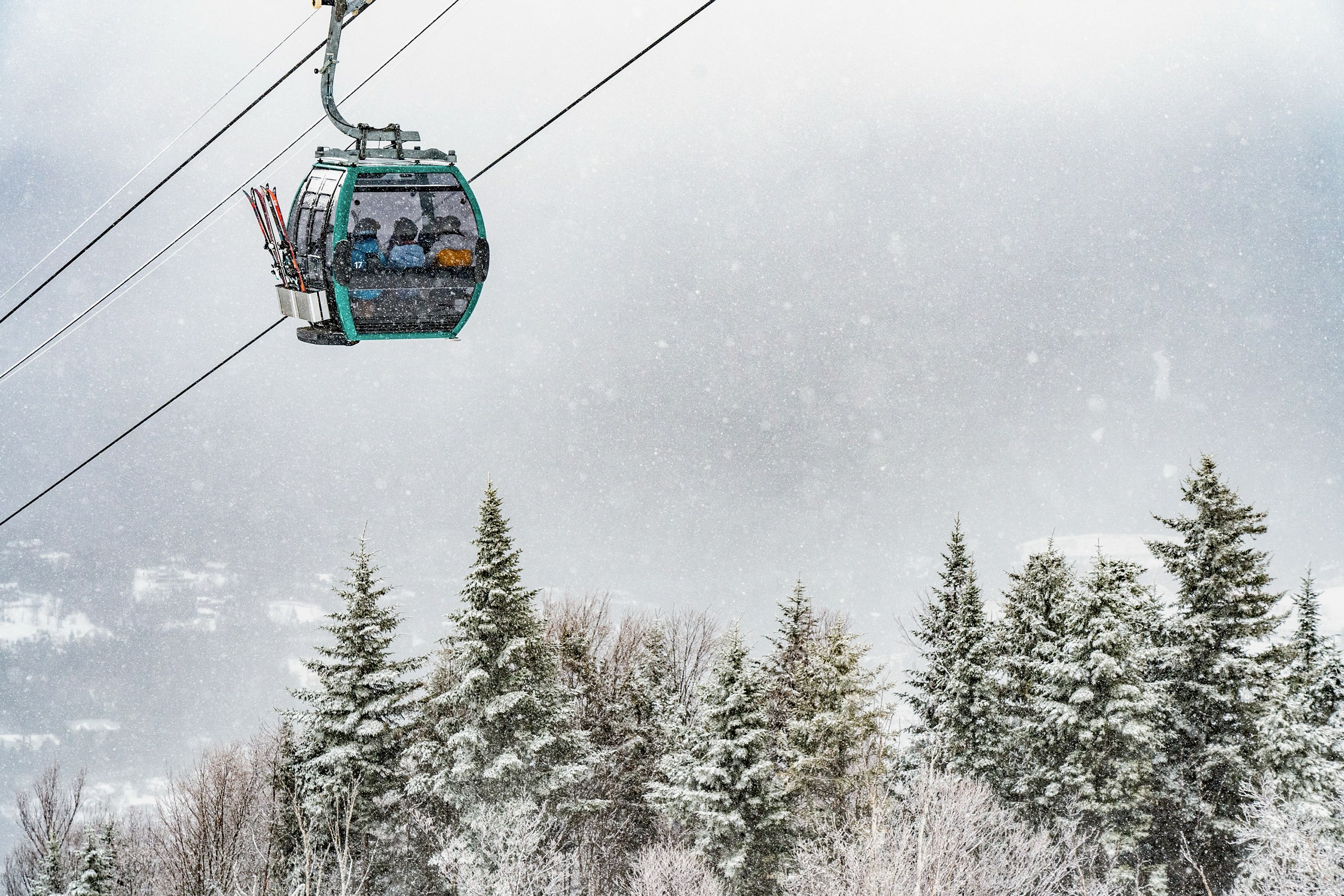 A ski gondola carries riders up a snowy mountain at Bretton Woods.