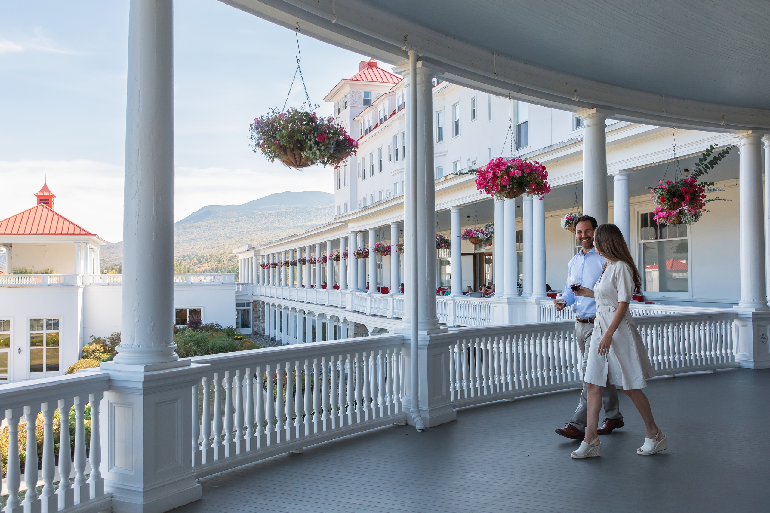 Young couple on the veranda at the Omni Mount Washington Resort and Spa during the afternoon in the summer.