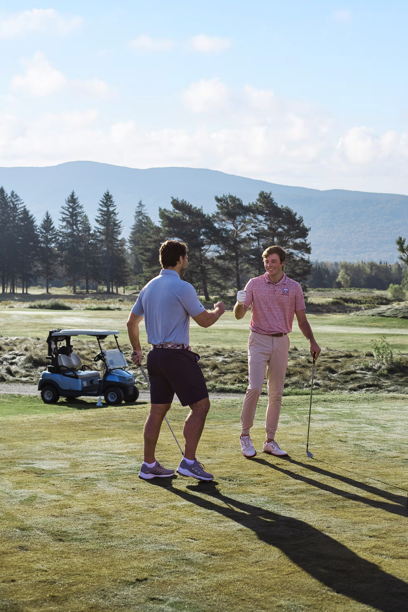 Two golfers giving high-fives during lessons at Bretton Woods