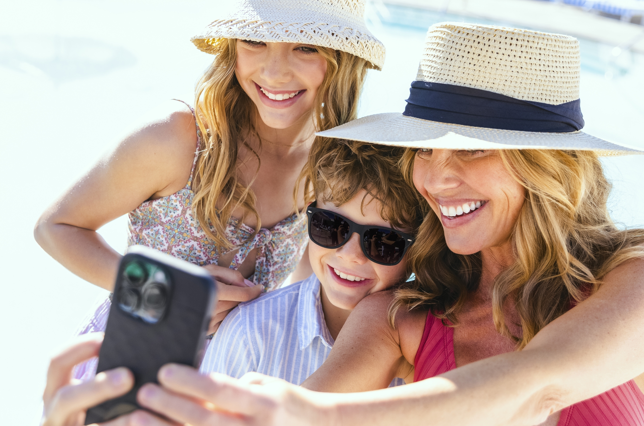 Mother and kids at the pool taking a selfie in the summer